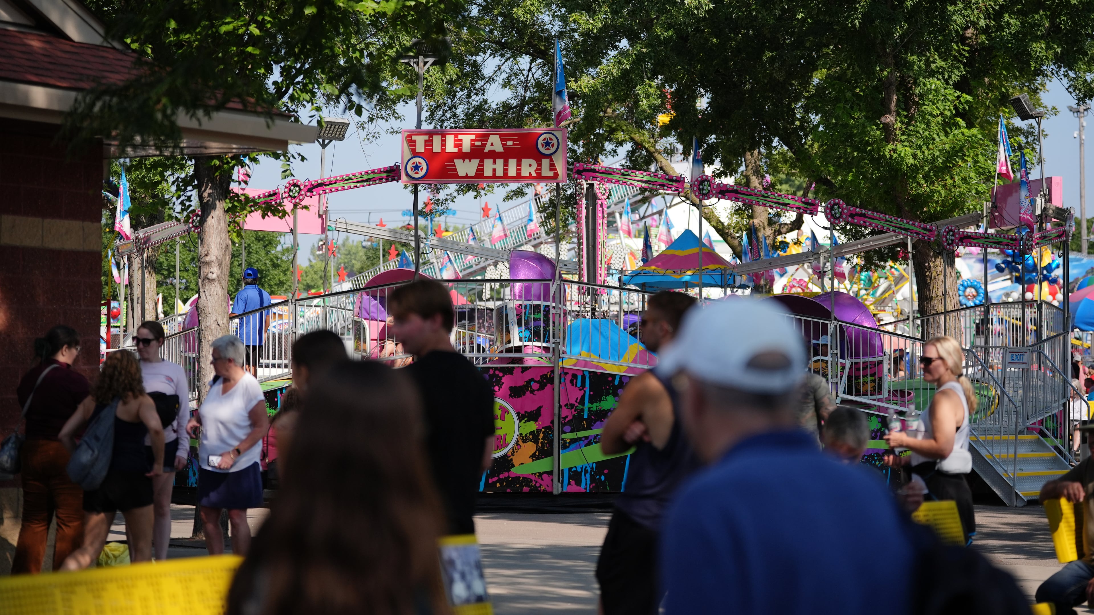 Fairgoers pass the Tilt-A-Whirl, Thursday, Aug. 27, 2026, at the Minnesota State Fair in Falcon Heights, Minn. (AP Photo/Ellen Schmidt)