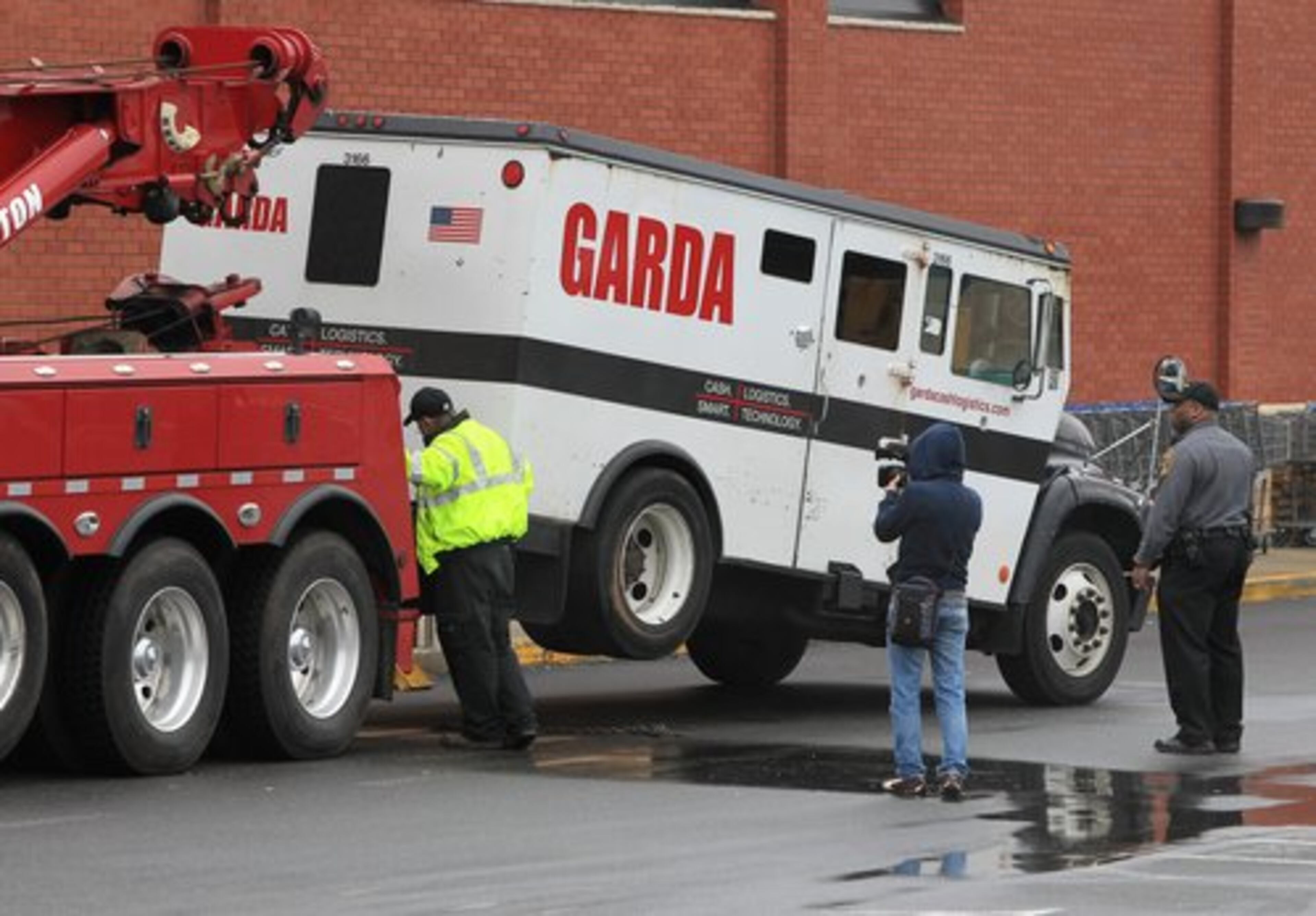 Authorities remove the armored vehicle from the scene of the daring robbery at the Kroger on Lavista Road at North Druid Hills. A courier was shot to death in the robbery.