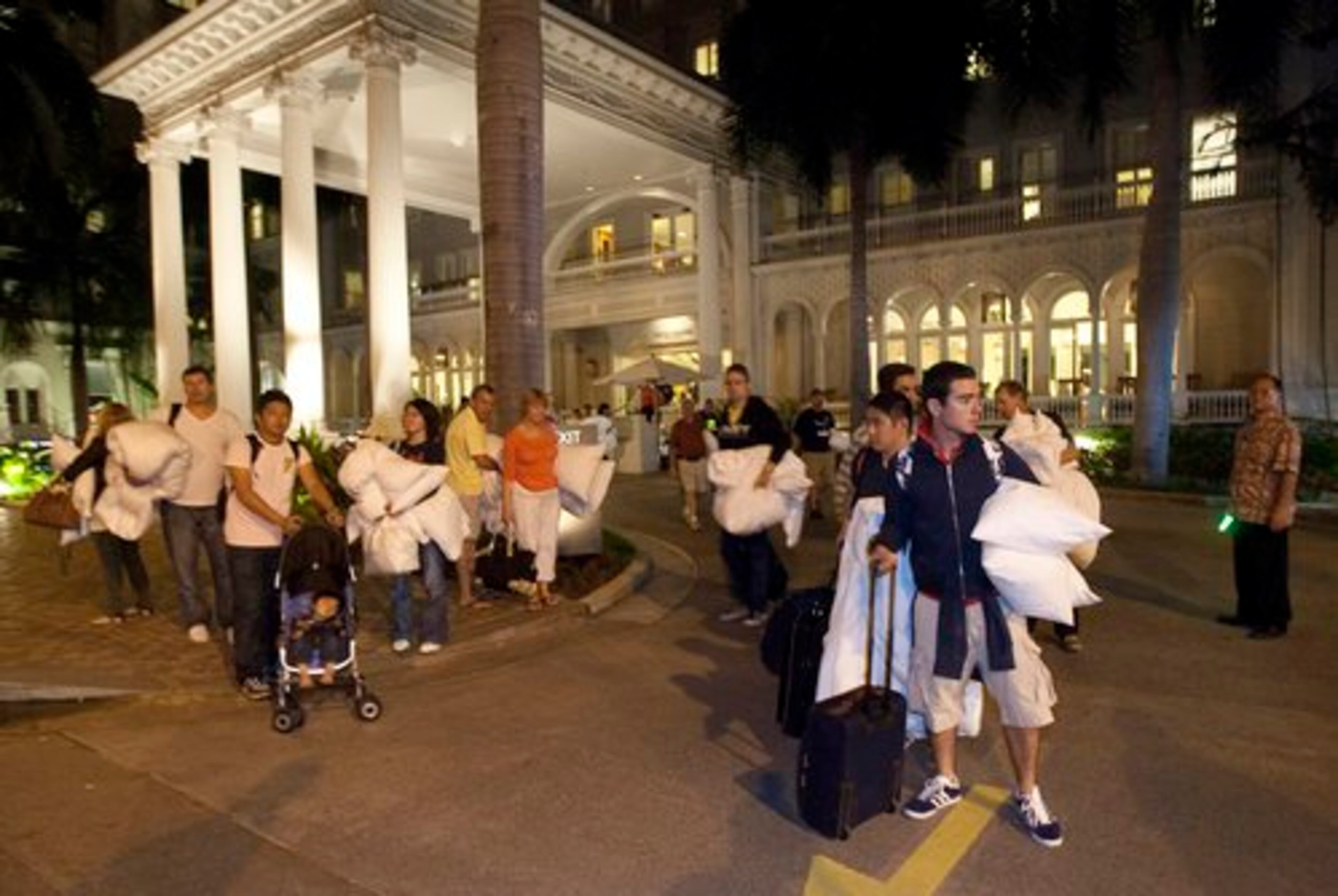 Hotel guests from the Moana Surfrider evacuate early Friday.