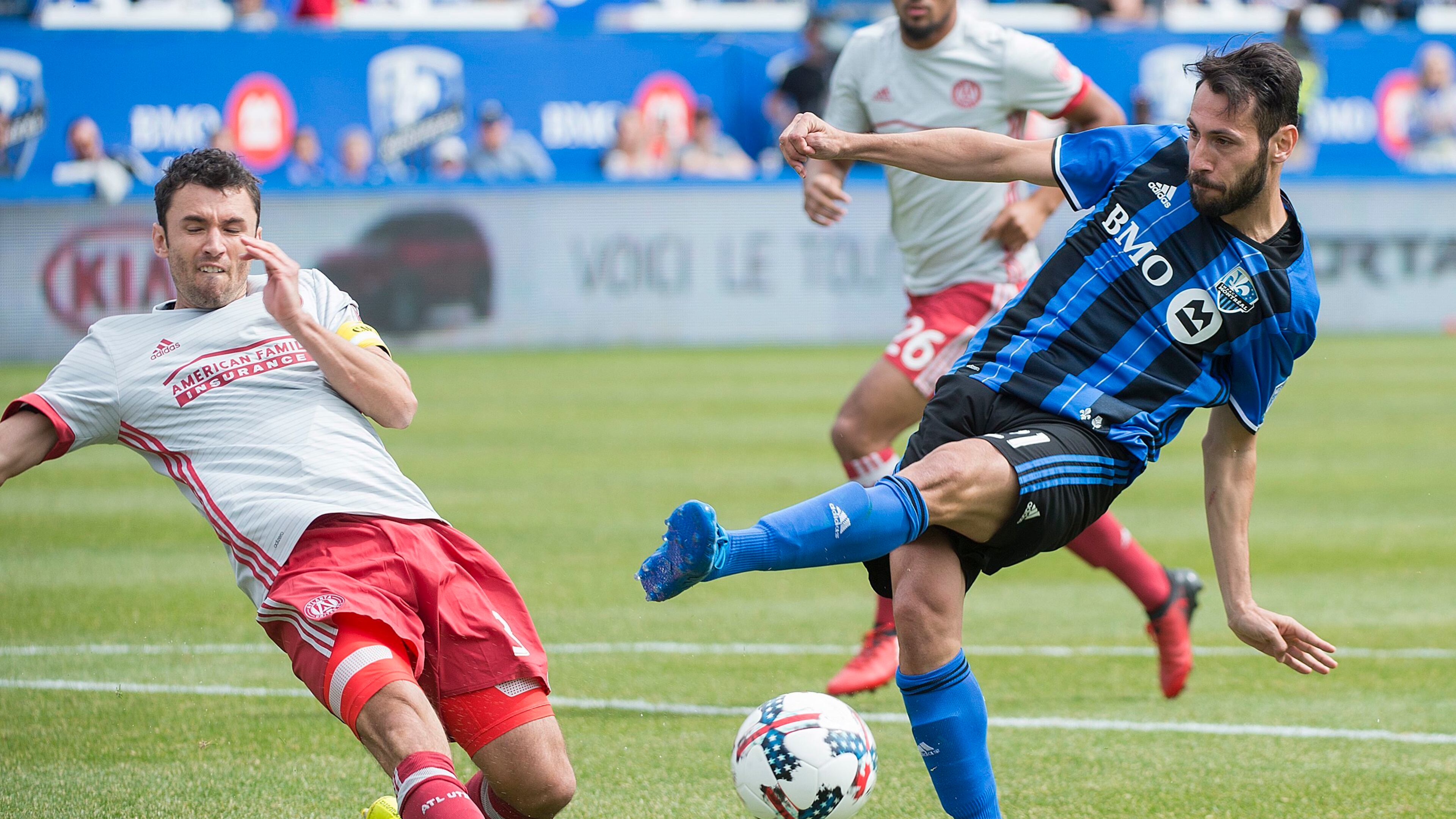 Montreal Impact's Matteo Mancosu, right, takes a shot as Atlanta United's Michael Parkhurst defends during second half MLS soccer action in Montreal, Saturday, April 15, 2017. (Graham Hughes/The Canadian Press via AP)