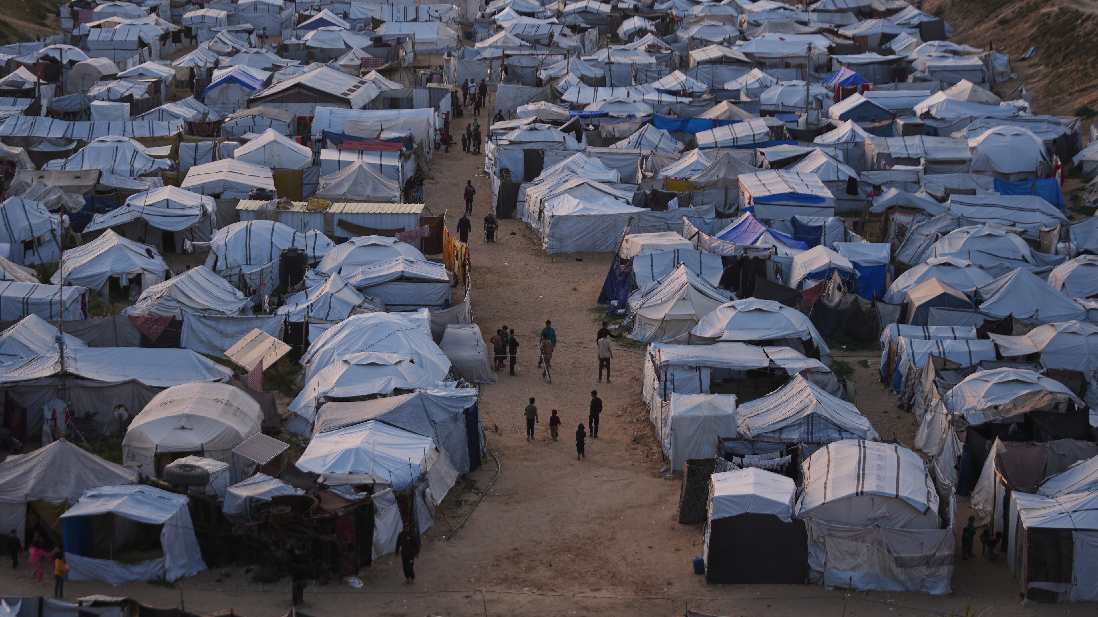 Palestinians walk along tents at a makeshift camp for displaced people in Khan Younis, southern Gaza Strip, Thursday, April 9, 2026. (AP Photo/Abdel Kareem Hana)