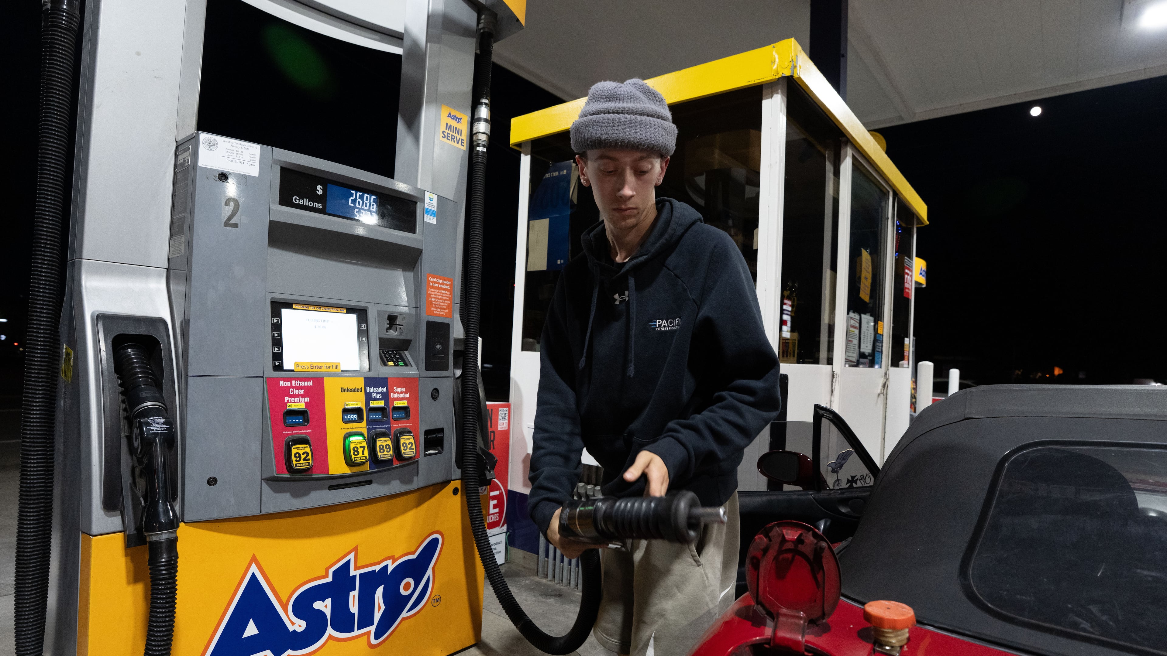 Luciano V. replaces the fuel nozzel after filling the tank of their 1999 Mazda Miata at an Astro gas station on Wednesday, April 29, 2026, in Portland, Ore. (AP Photo/Jenny Kane)