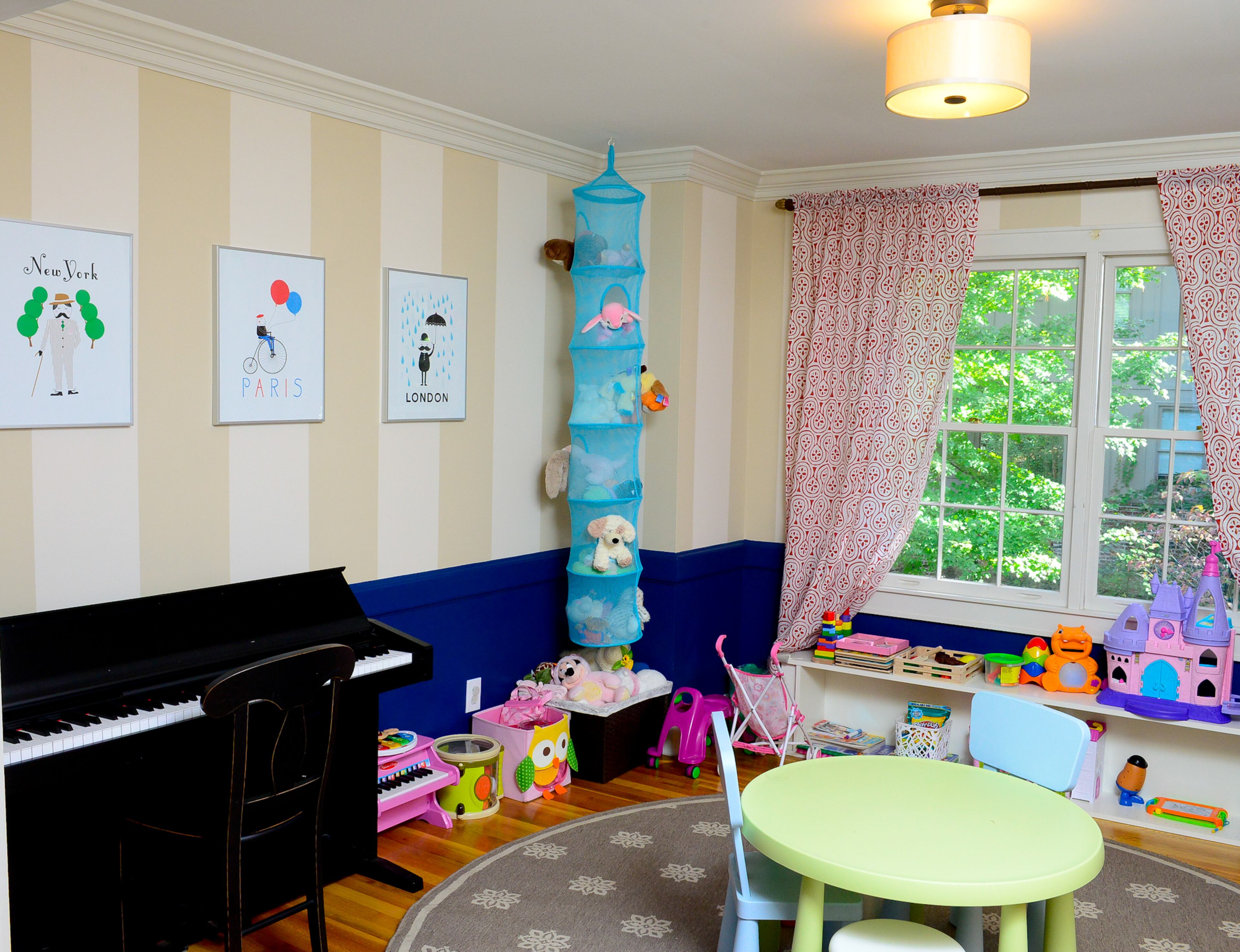 With striped walls, the formal dining room transitions nicely into a playroom for their daughter. There's room for tea parties, playing the keyboard and other kid-friendly activities in the room, which has framed prints from IKEA.