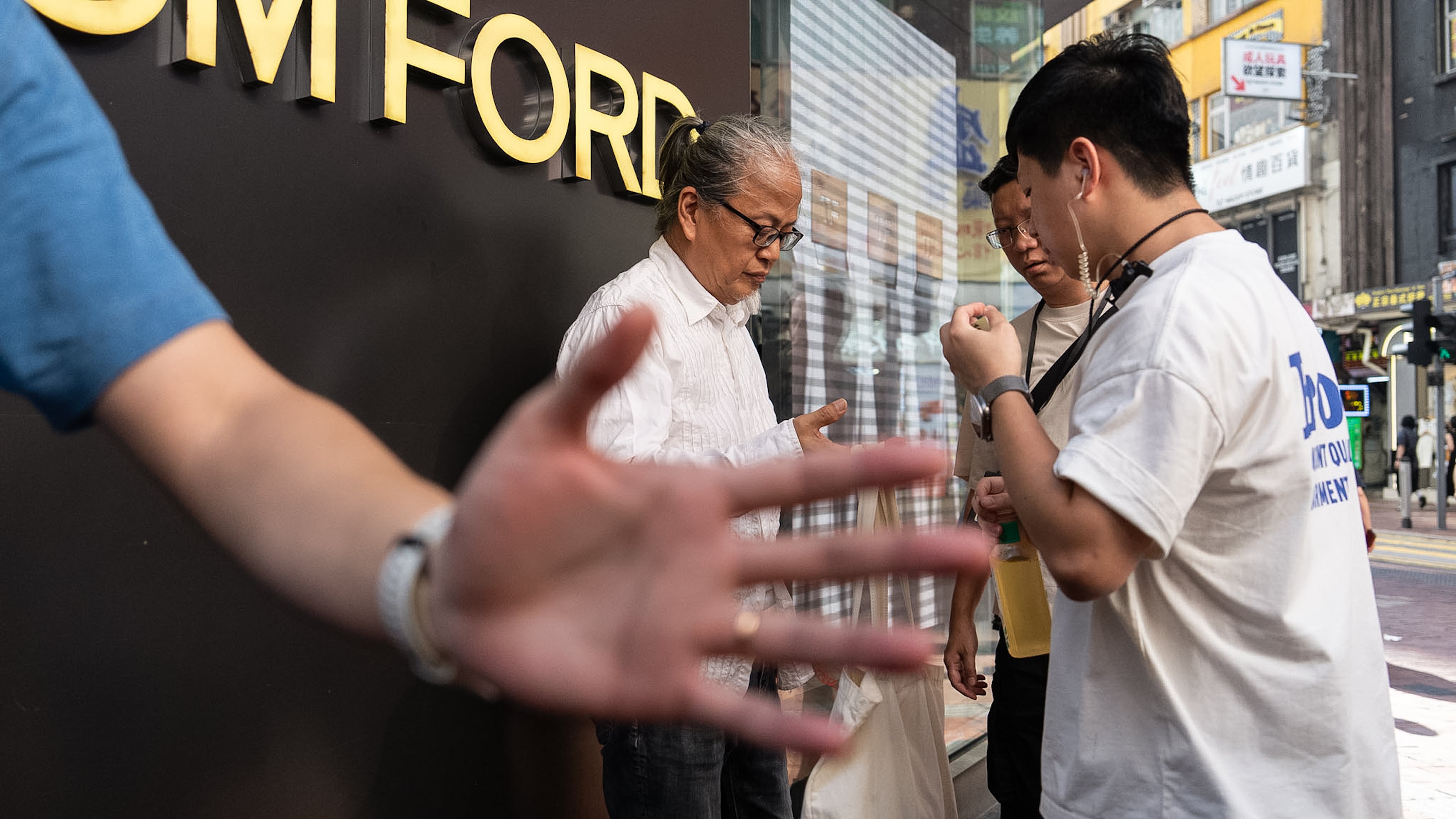 Police officers stop and search artist Sanmu Chen in the Causeway Bay area on the eve of the 37th anniversary of China's Tiananmen Square crackdown in Hong Kong, Wednesday, June 3, 2026. (AP Photo/Chan Long Hei)