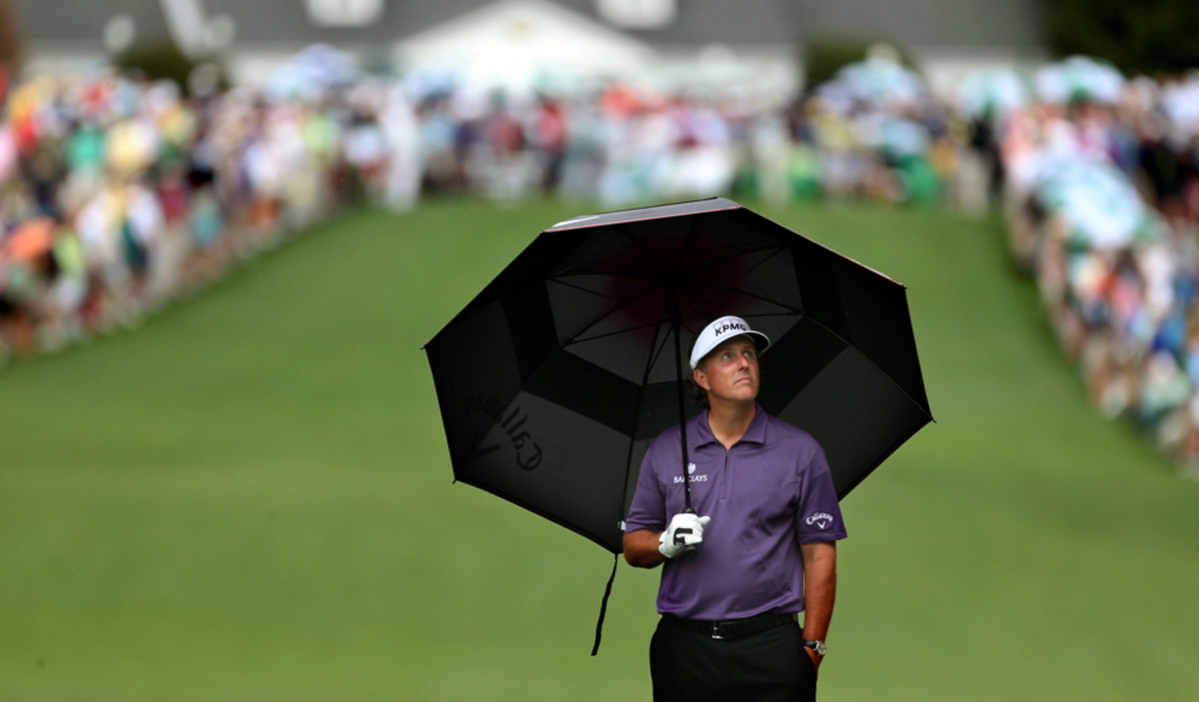 APRIL 12, 2013 AUGUSTA: Phil Mickelson checks the weather from under an umbrella on the No.1 fairway during the second round in the Masters Tournament at Augusta National Golf Club on Friday April 12 2013. Getz said, "The weather is a part of covering the Masters. I'm drawn to graphic images and the simplicity of the umbrella and the body language of Mickelson makes this image." JASON GETZ / JGETZ@AJC.COM