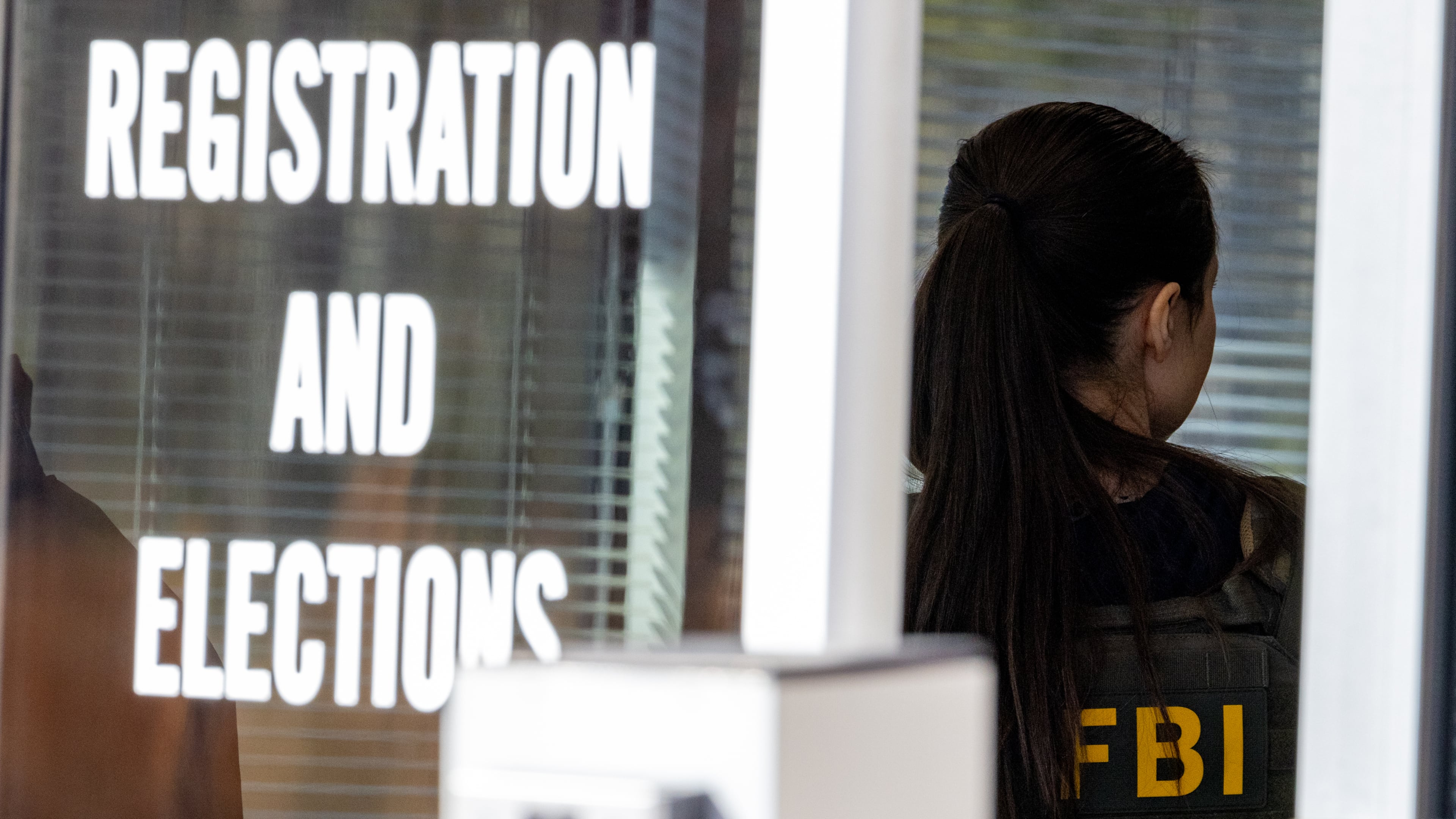 An FBI agent stands inside the entrance to the Fulton County Election Hub and Operation Center in Union City on Wednesday, Jan. 28, 2026. (Arvin Temkar/AJC)