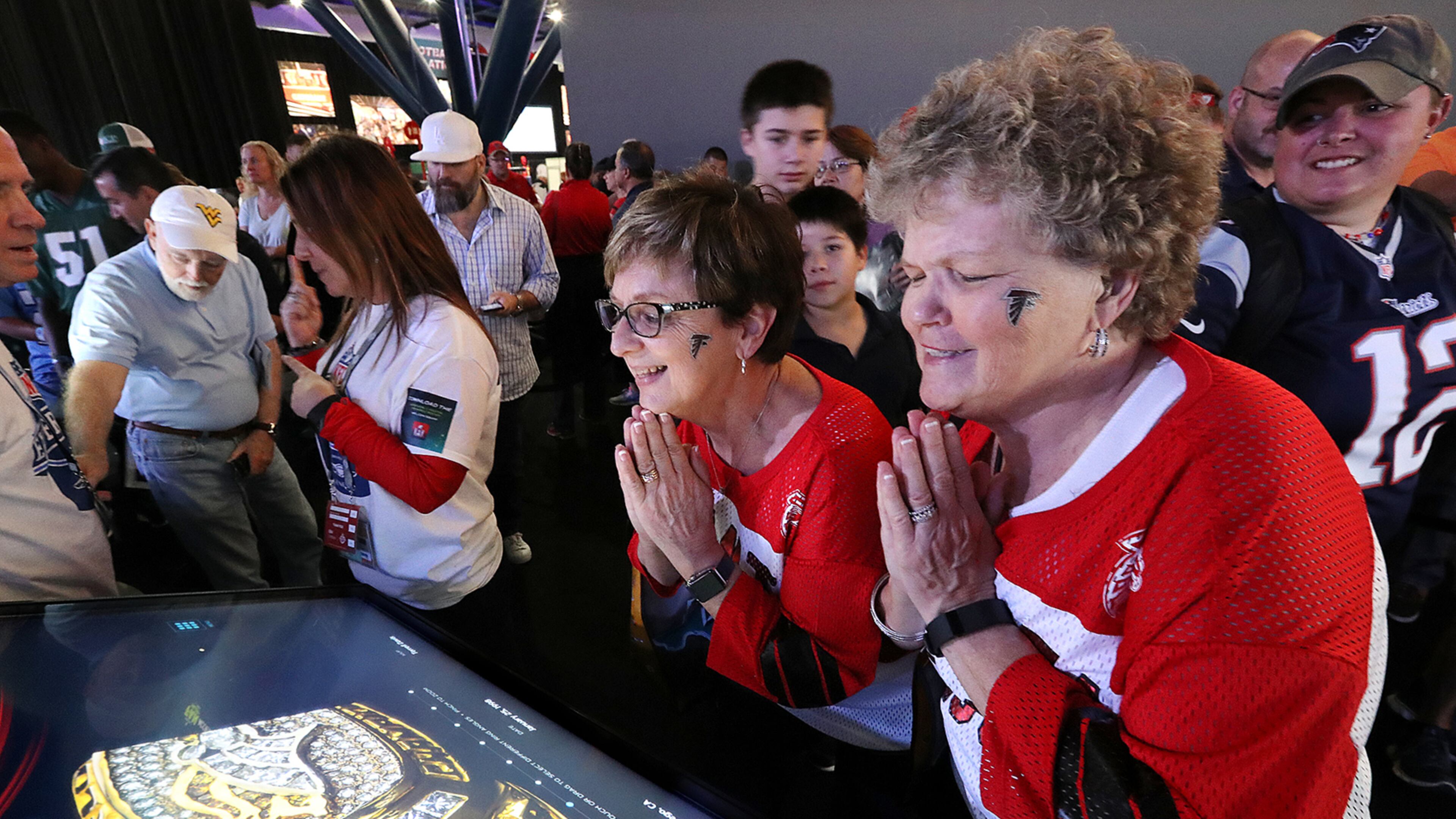 Falcons fans Sharon Vickery (from left) and Diane Page, both from Canton, take in the Super Bowl rings exhibit while Patriots fan Jesssalyn DiManno looks on while joining the thousands of football fans in town for the Super Bowl as they take in the pro football interactive theme park the NFL Experience on Thursday, Feb. 2, 2017, in Houston.