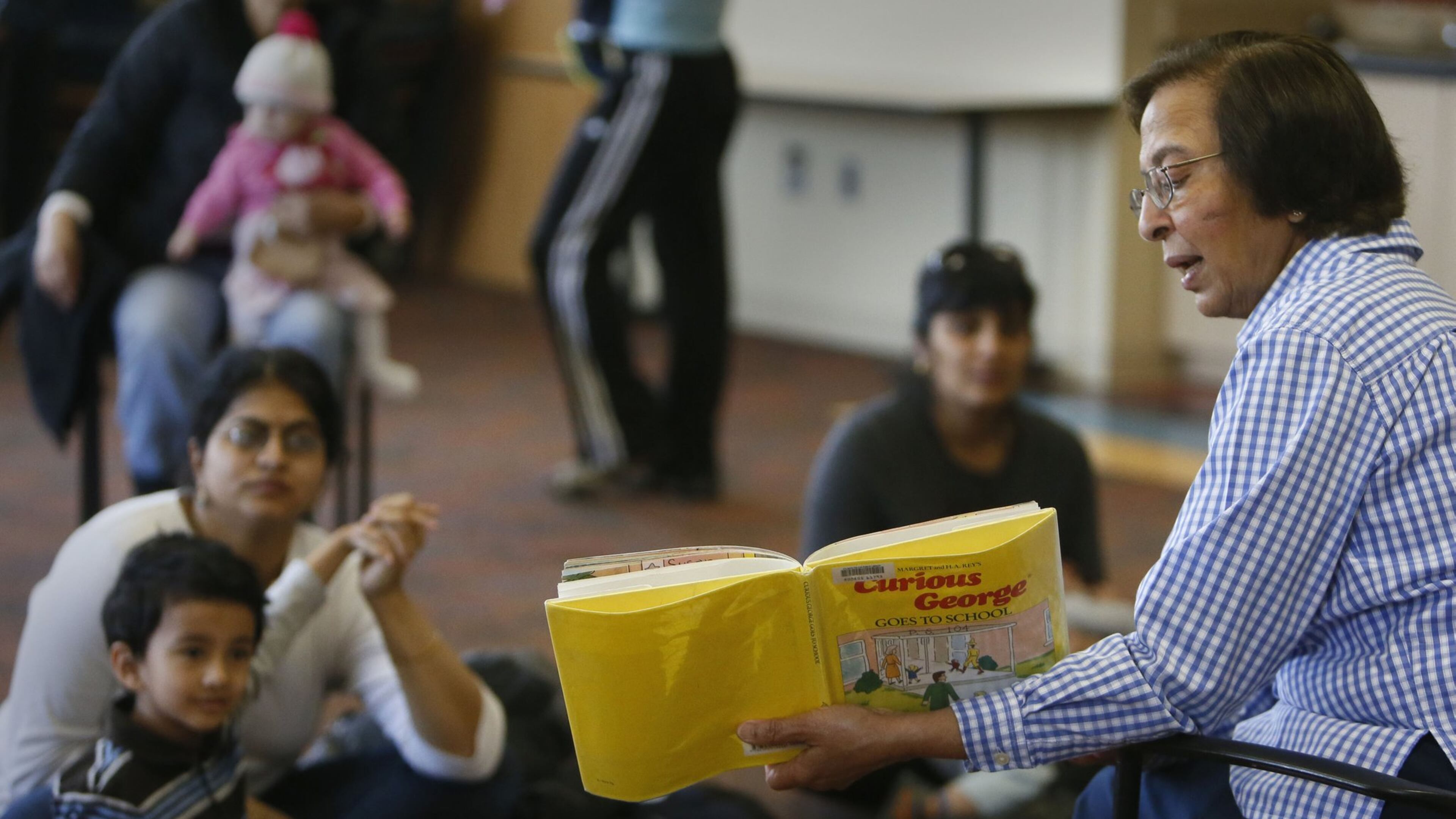 Library associate Vinita Chugani reads to children every thursday during Preschool Storytime at the Ocee Branch Library in Johns Creek. After years of avoiding it, Fulton County made some tough cuts when it passed its 2014 budget. Among other things, the budget will shutter libraries up to two days a week, boost fees for senior programs and raise taxes on homeowners. BOB ANDRES / BANDRES@AJC.COM