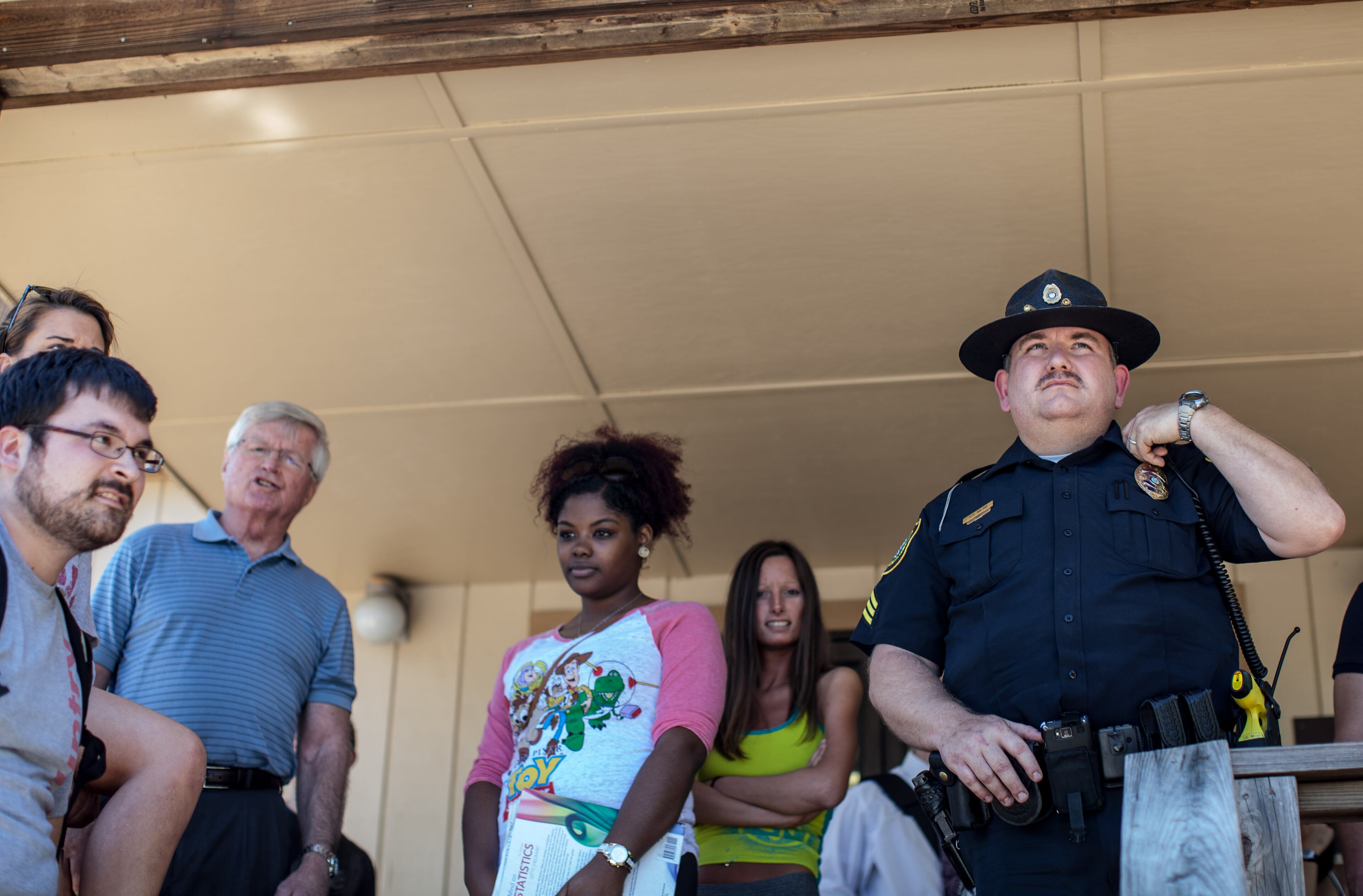 An Officer and students stand near a building on Kennesaw State University's campus during a lockdown after hearing of a possible gunman on campus Friday, April 25, 2014. (BRANDEN CAMP/ SPECIAL)