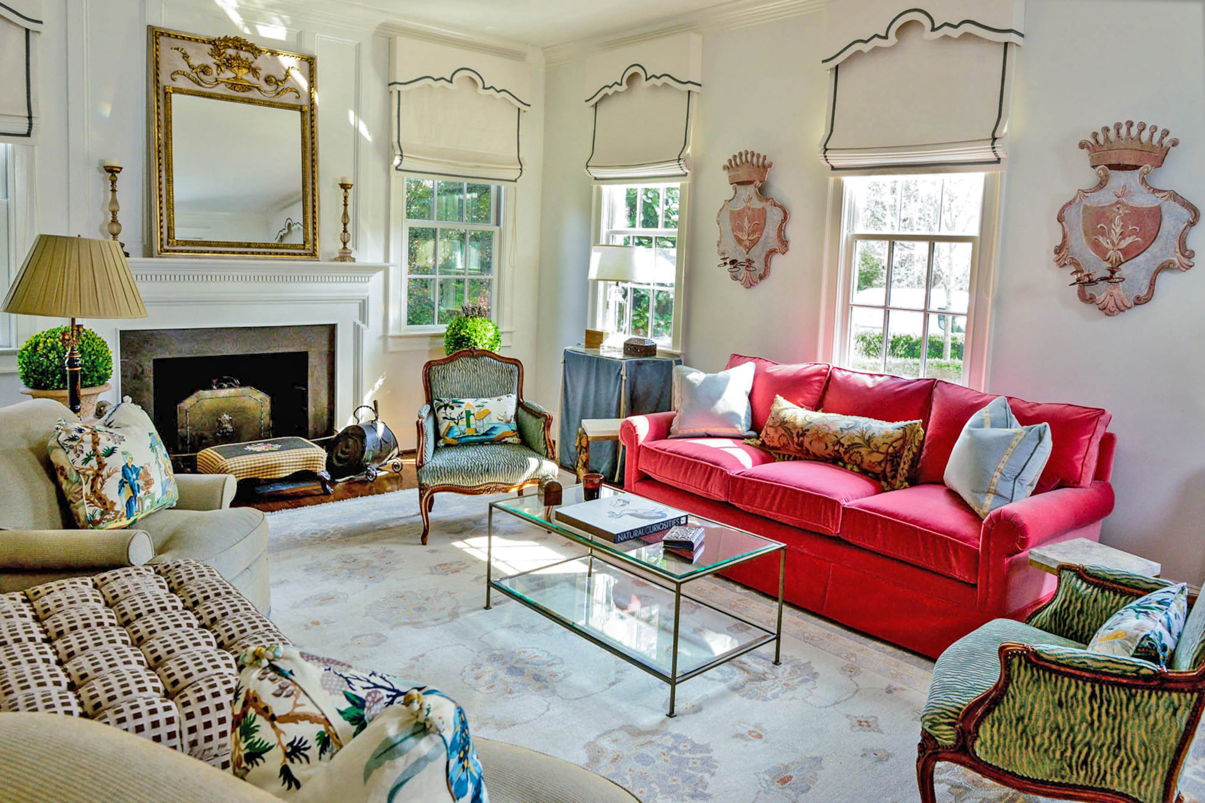 A pair of Italian candle sconces found at Scott Antique Markets hang above a pink sofa that homeowner Dina Woodruff said was inspired by Lacefield pillows.