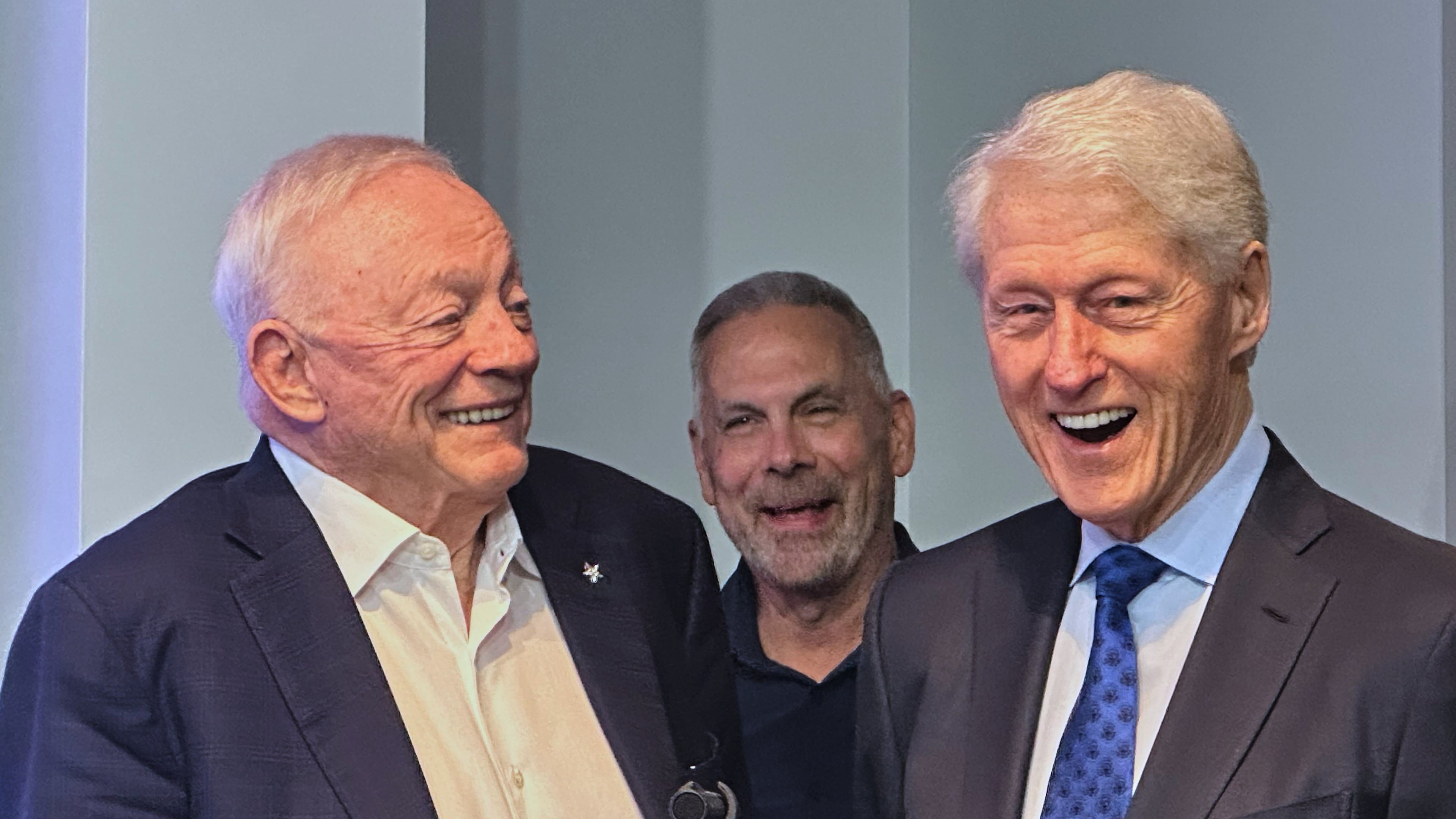 Former U.S. President Bill Clinton, right, laughs alongside Dallas Cowboys owner Jerry Jones, left, and Cowboys senior vice president of communications Tad Carper, center, during the NFL football team's pre-draft news conference Wednesday, April 22, 2026 in Frisco, Texas. (AP Photo/Schuyler Dixon)