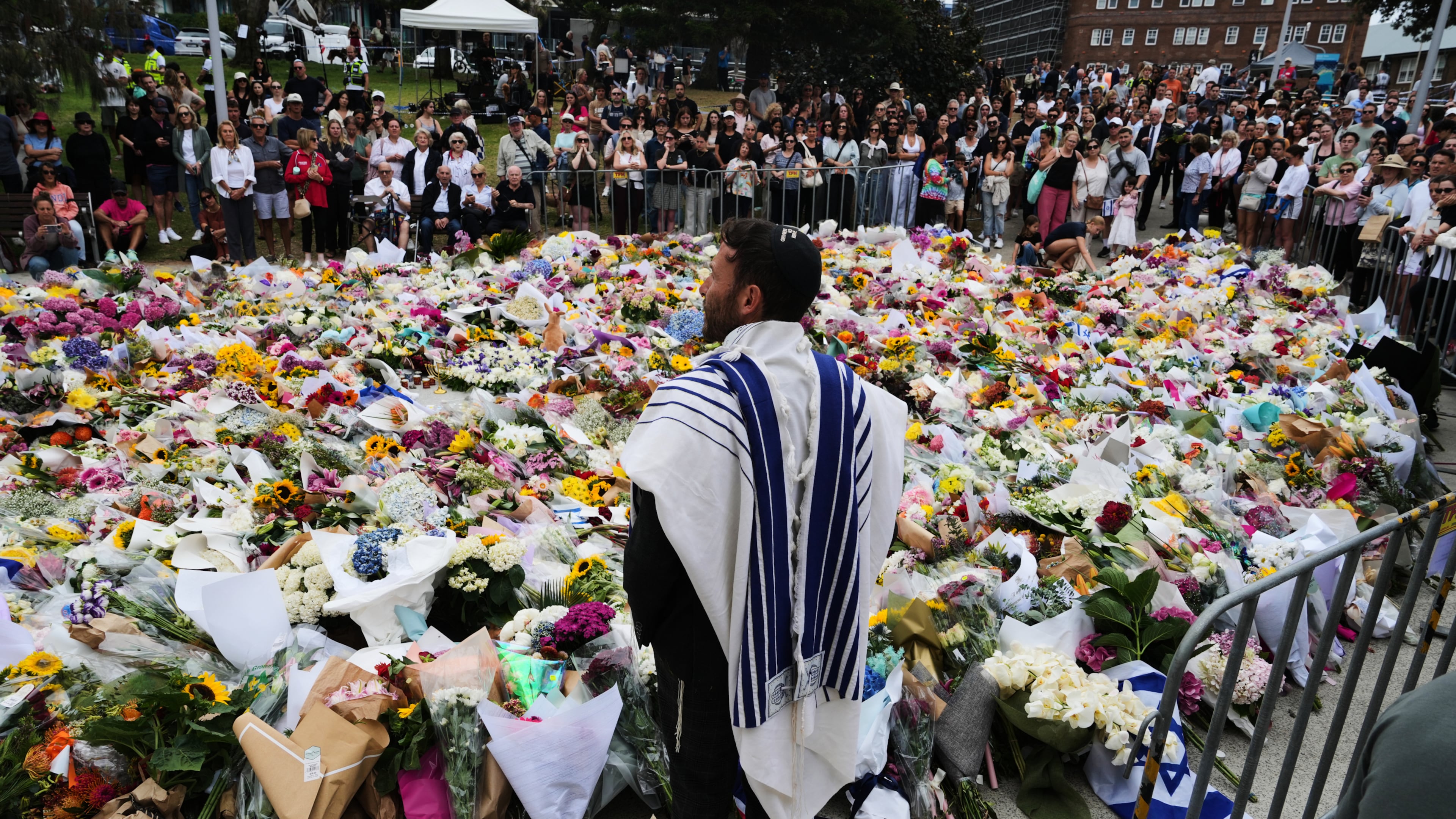 FILE - Rabbi Yossi Friedman speaks to people gathering at a flower memorial by the Bondi Pavilion at Bondi Beach on Tuesday, Dec. 16, 2025, following Sunday's shooting in Sydney, Australia. (AP Photo/Mark Baker, File)