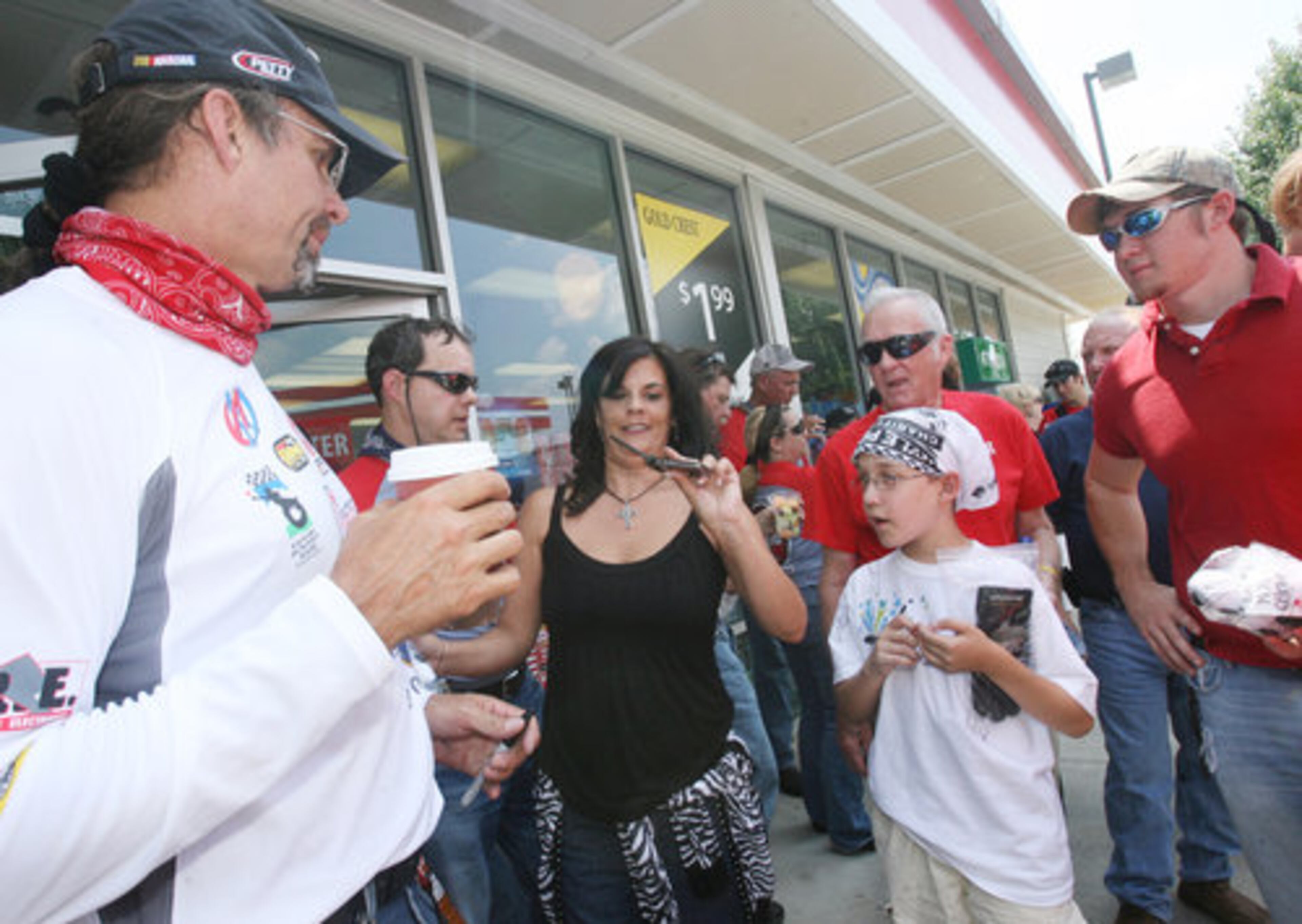 With something to cool him down, Petty chats with Tony (lower right) and Andy Velo. The charity motorcycle ride is for the Victory Junction Gang Camp for chronically ill children, founded by Petty.