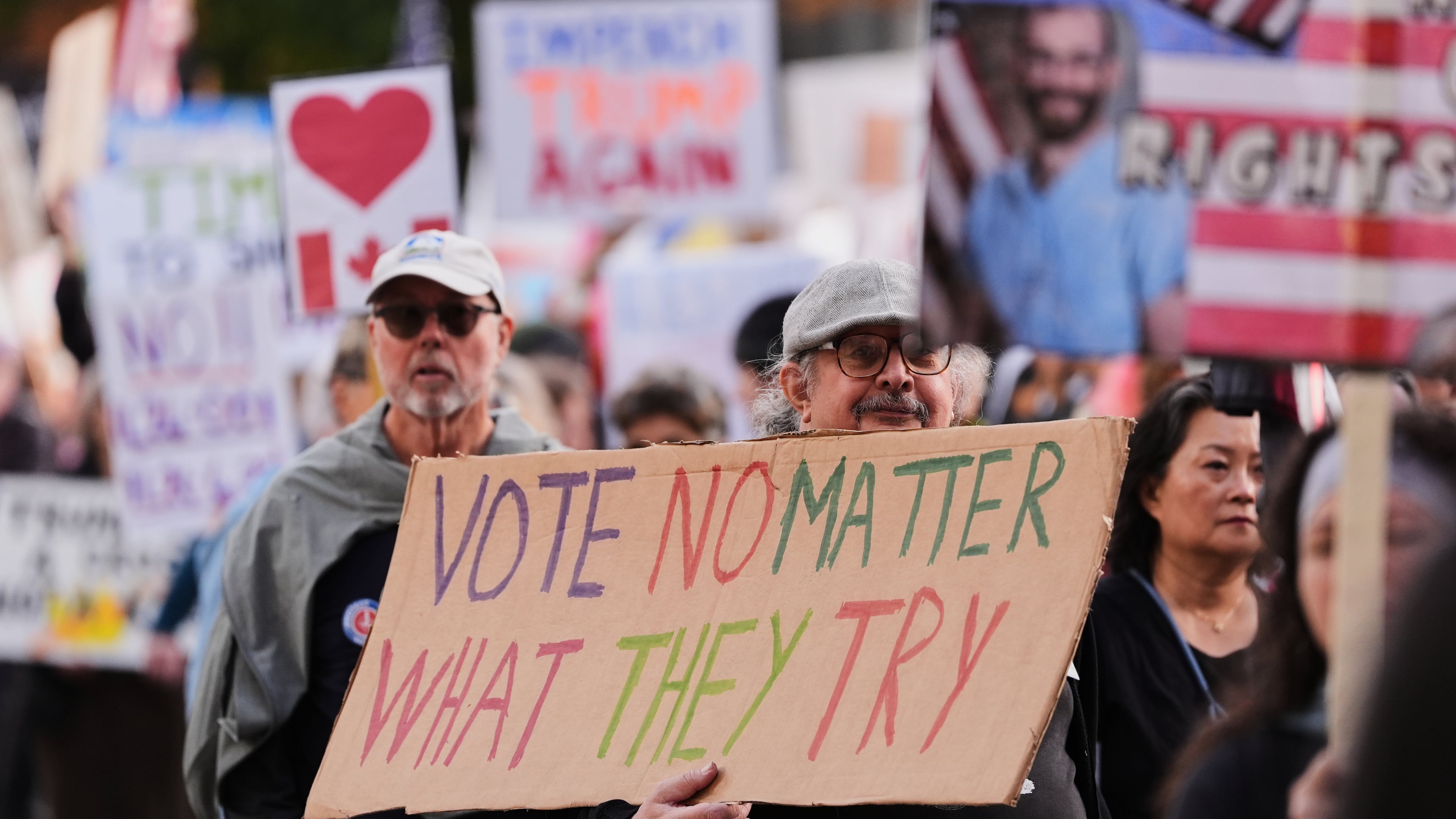 A person holds a sign during a "No Kings" protest march encouraging early voting Saturday, Oct. 17, 2026, in Seattle. (AP Photo/Lindsey Wasson)
