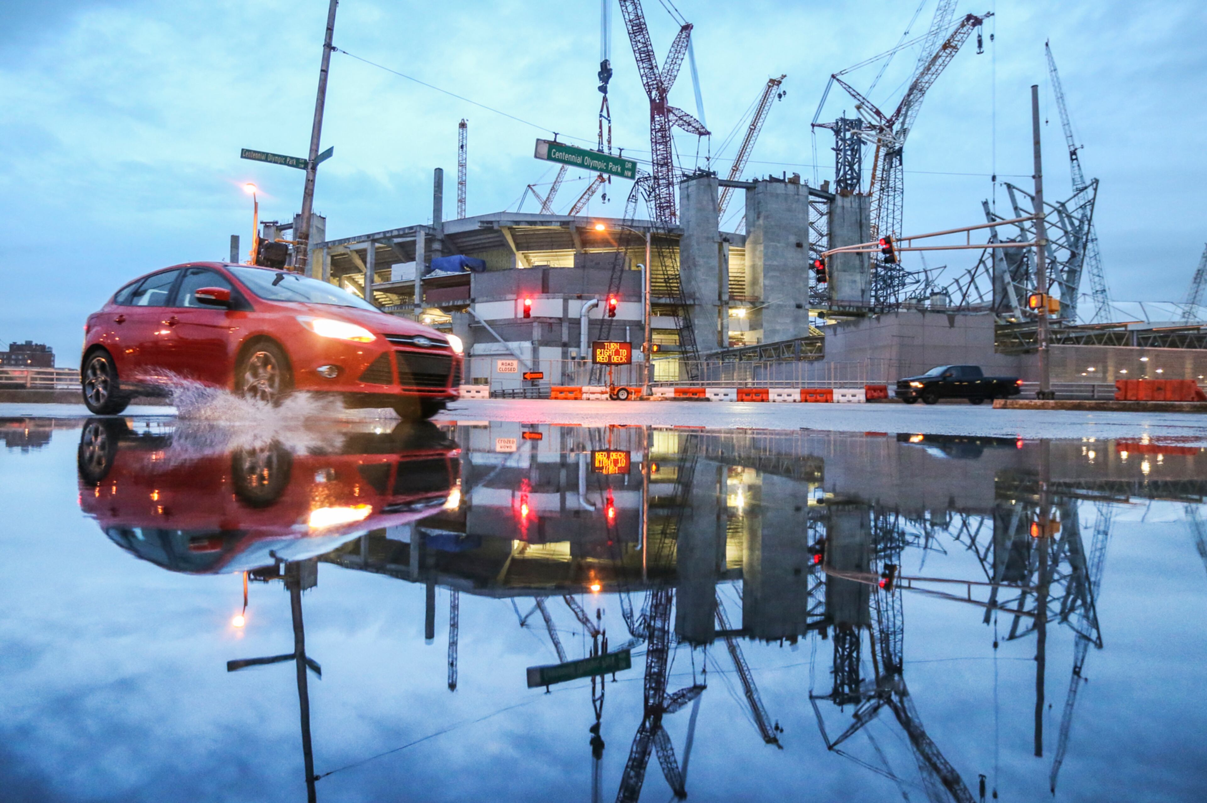 April 22, 2016 : Atlanta: This Atlanta motorist navigated with a splash through a large puddle of water reflecting the rising Mercedes Benz stadium under construction at Centennial Olympic Park Drive and Martin Luther King Jr. Drive. Rain moved in across metro Atlanta on Friday, Apr. 22, 2016 but sunny days are in store for the weekend. Channel 2 meteorologist Karen Minton said Highs will be in the mid- to upper 70s Saturday and linger in the 80s Sunday through Tuesday. Conditions will stay dry through Wednesday, Minton said. JOHN SPINK / JSPINK@AJC.COM