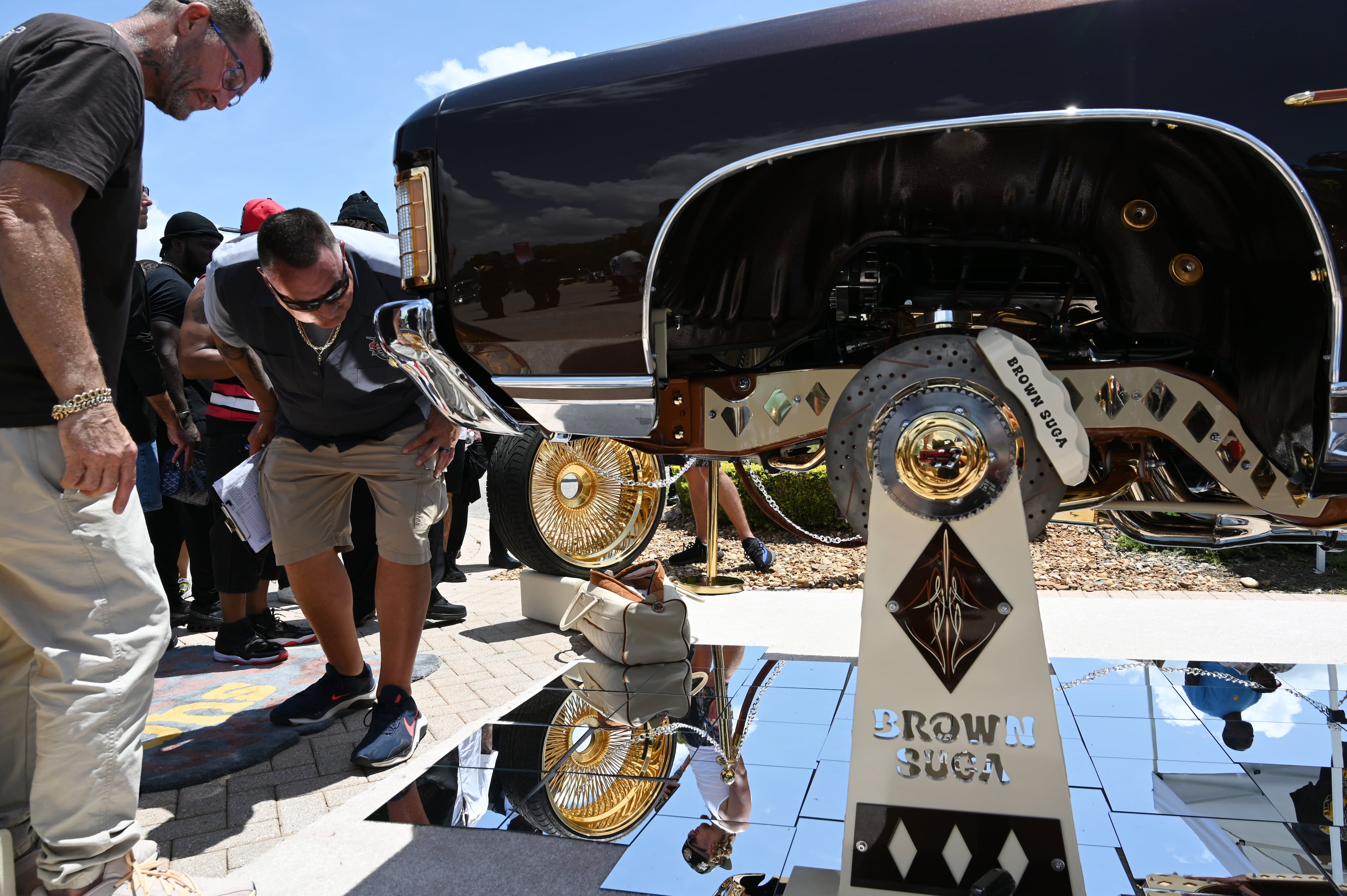 Attendees walk through fleets of classic/custom automobiles, luxury vehicles, boats, RVs and trailers on the front of the mansion during the 4th Annual Rick Ross Car and Bike Show, Saturday, June 7, 2025, in Fayetteville. The 4th Annual Rick Ross Car and Bike Show will include a vendor market with more than 30 vendors, food trucks, fleets of classic/custom automobiles, luxury vehicles, boats, RVs and trailers on the front of the mansion. Stage performances include Plies, Ross' new signee Nino Breeze and Ross himself. (Hyosub Shin / AJC)