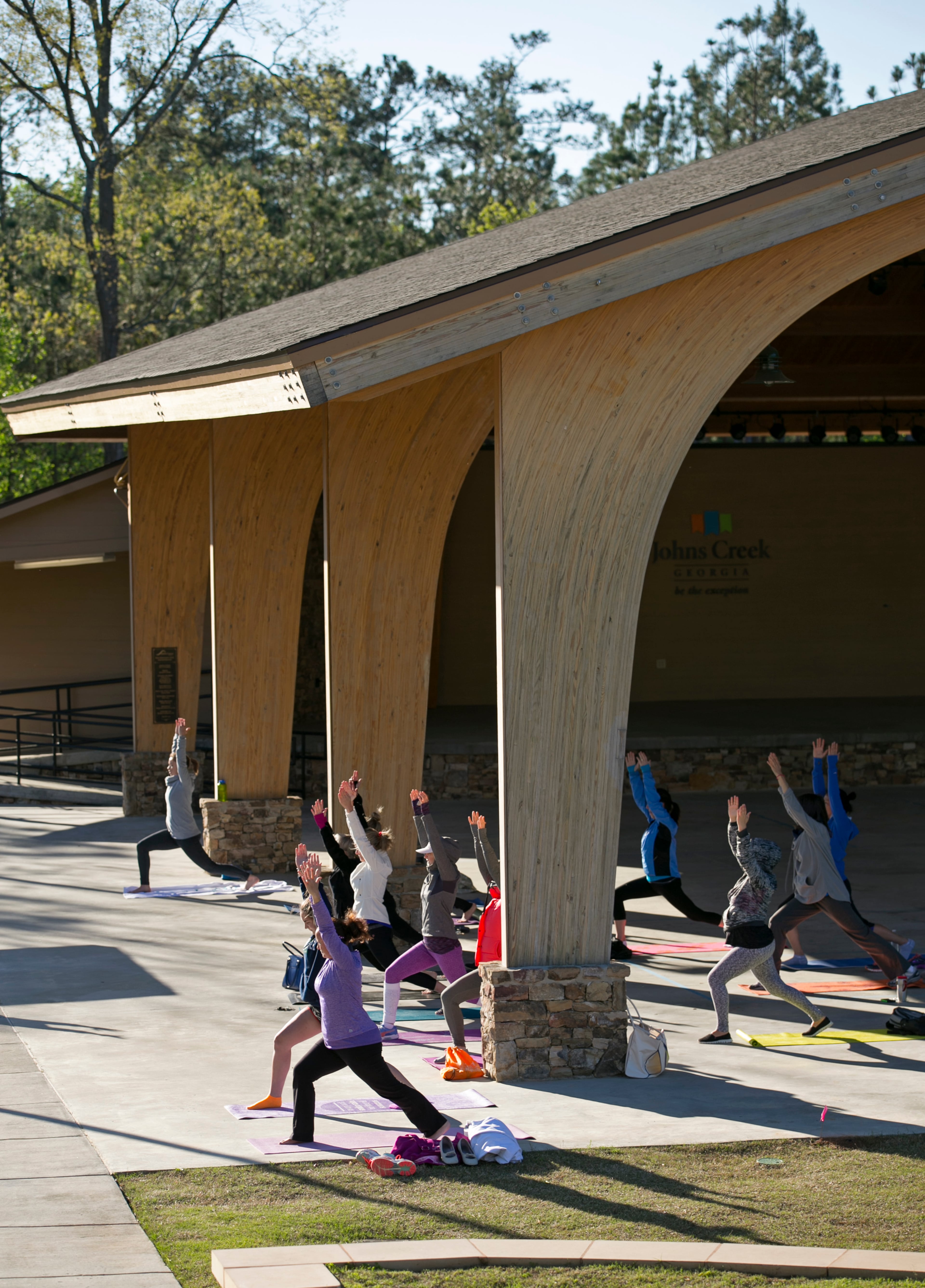 April 3, 2016 - Johns Creek, Ga: A group of women participate in a free yoga class at the Newtown Park Amphitheater at Newtown Park Sunday, April 3, 2016, in Johns Creek, Ga. The class was taught by Anissa Dearborn. This is for the insider's guide feature about the Newtown neighborhood. PHOTO / JASON GETZ