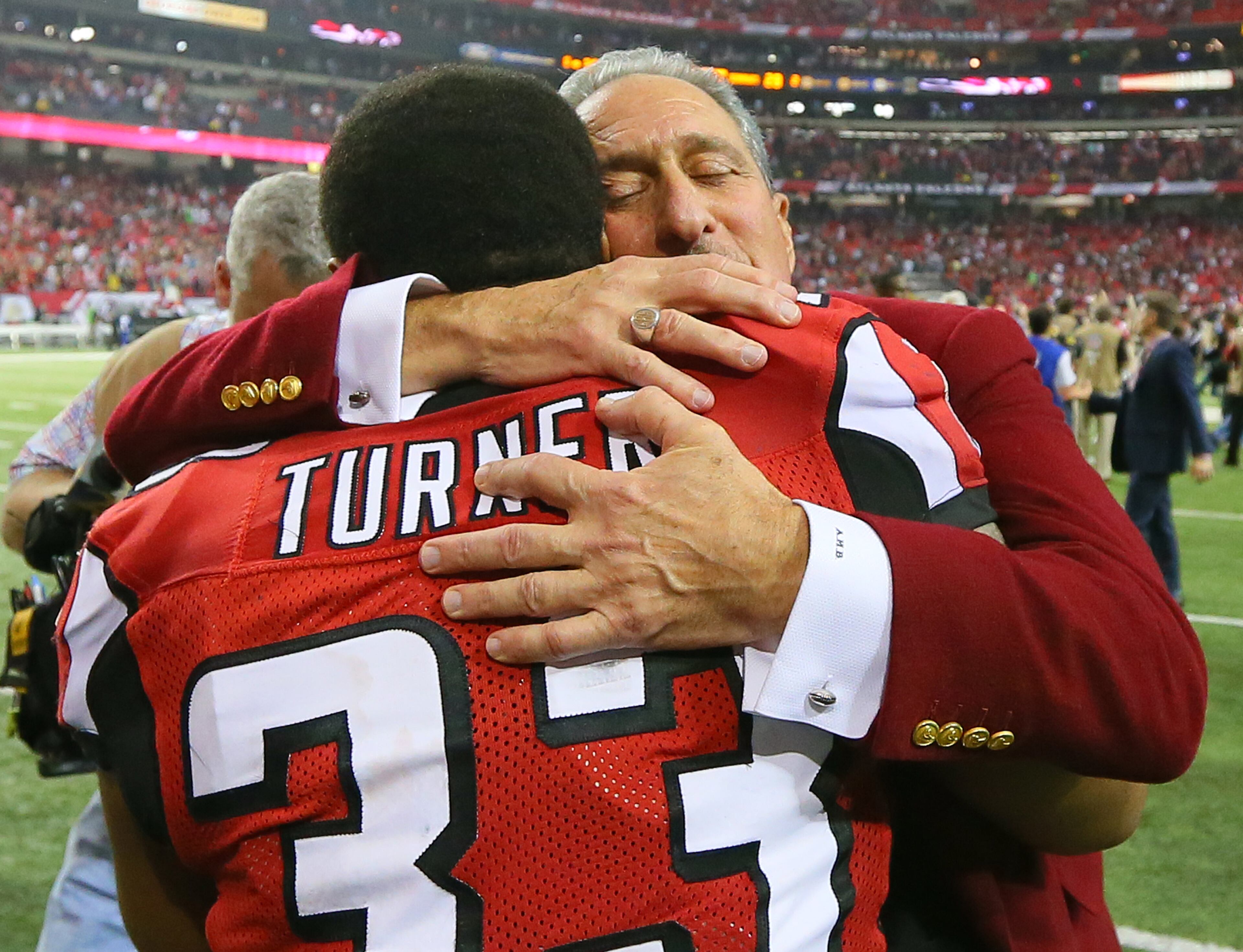 011313 ATLANTA : Falcons owner Arthur Blank hugs running back Michael Turner after beating the Seahawks 30-28 at the Georgia Dome in Atlanta on Sunday, Jan. 13, 2013. CURTIS COMPTON / CCOMPTON@AJC.COM