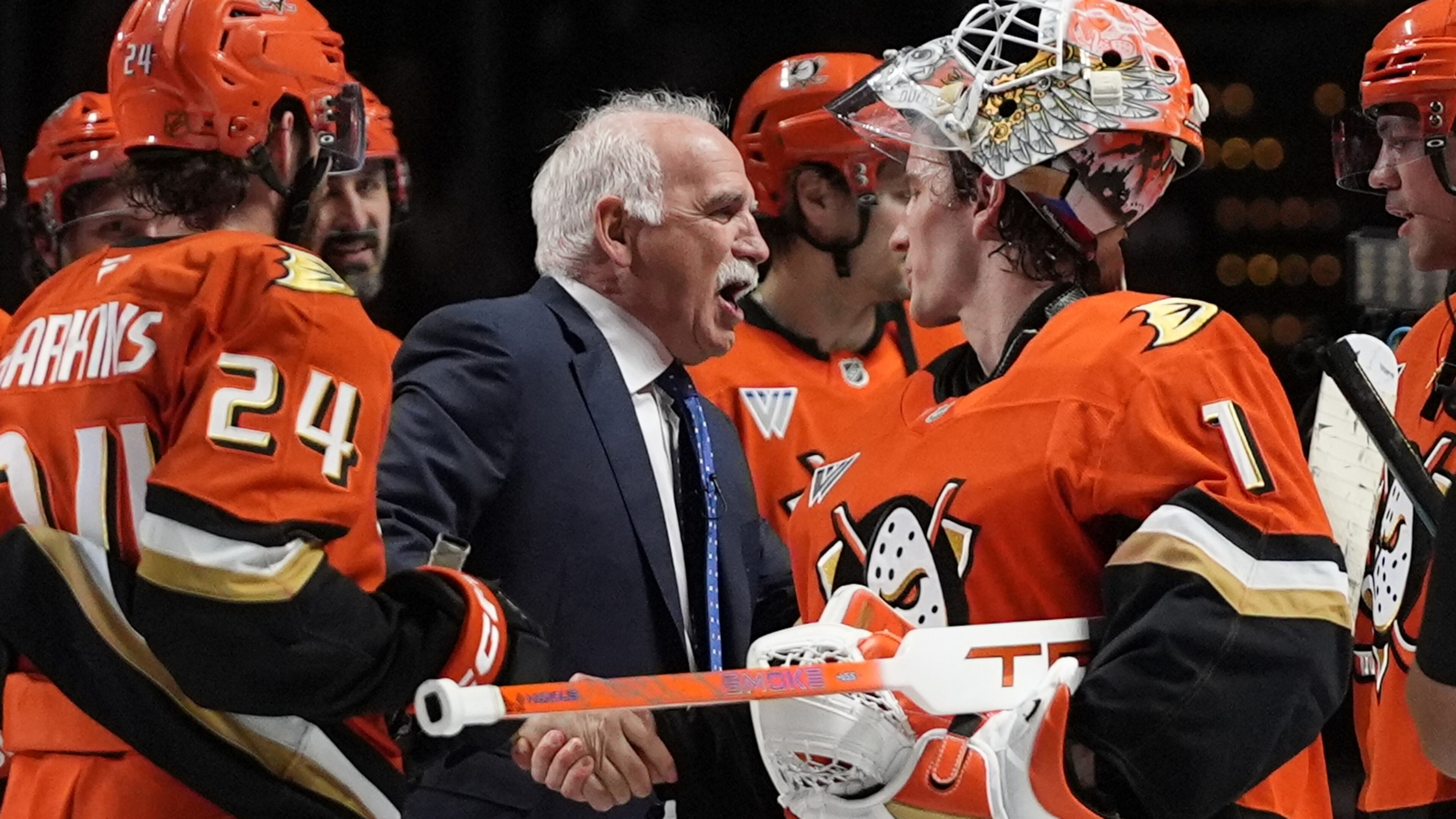 Anaheim Ducks head coach Joel Quenneville, center, celebrates with goaltender Lukas Dostal (1) after winning his 1,000th career coaching victory with a 6-4 win over the Edmonton Oilers in an NHL hockey game Wednesday, Feb. 25, 2026, in Anaheim, Calif. (AP Photo/Gregory Bull)