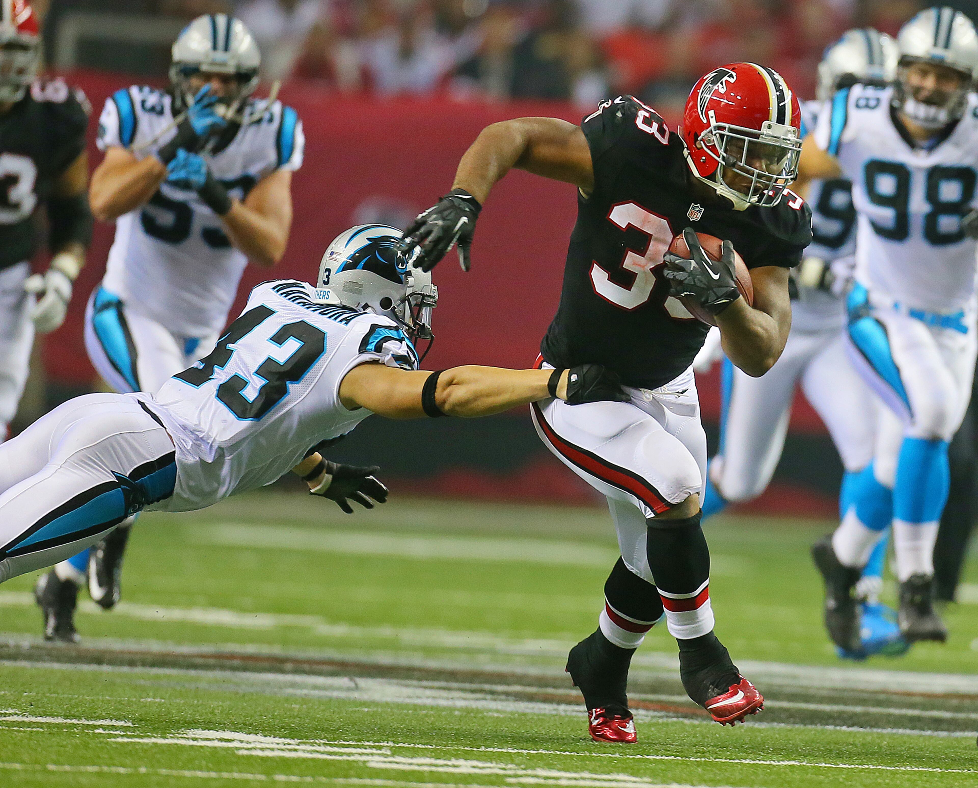 093012 ATLANTA: --TURNER BREAKS OUT-- Atlanta Falcons running back Michael Turner breaks away from Carolina Panthers safety Haruki Nakamura for a 60-yard touchdown reception and run and a 24-14 lead during the third quarter at the Georgia Dome in Atlanta on Sunday , Sept. 30, 2012. CURTIS COMPTON / CCOMPTON@AJC.COM