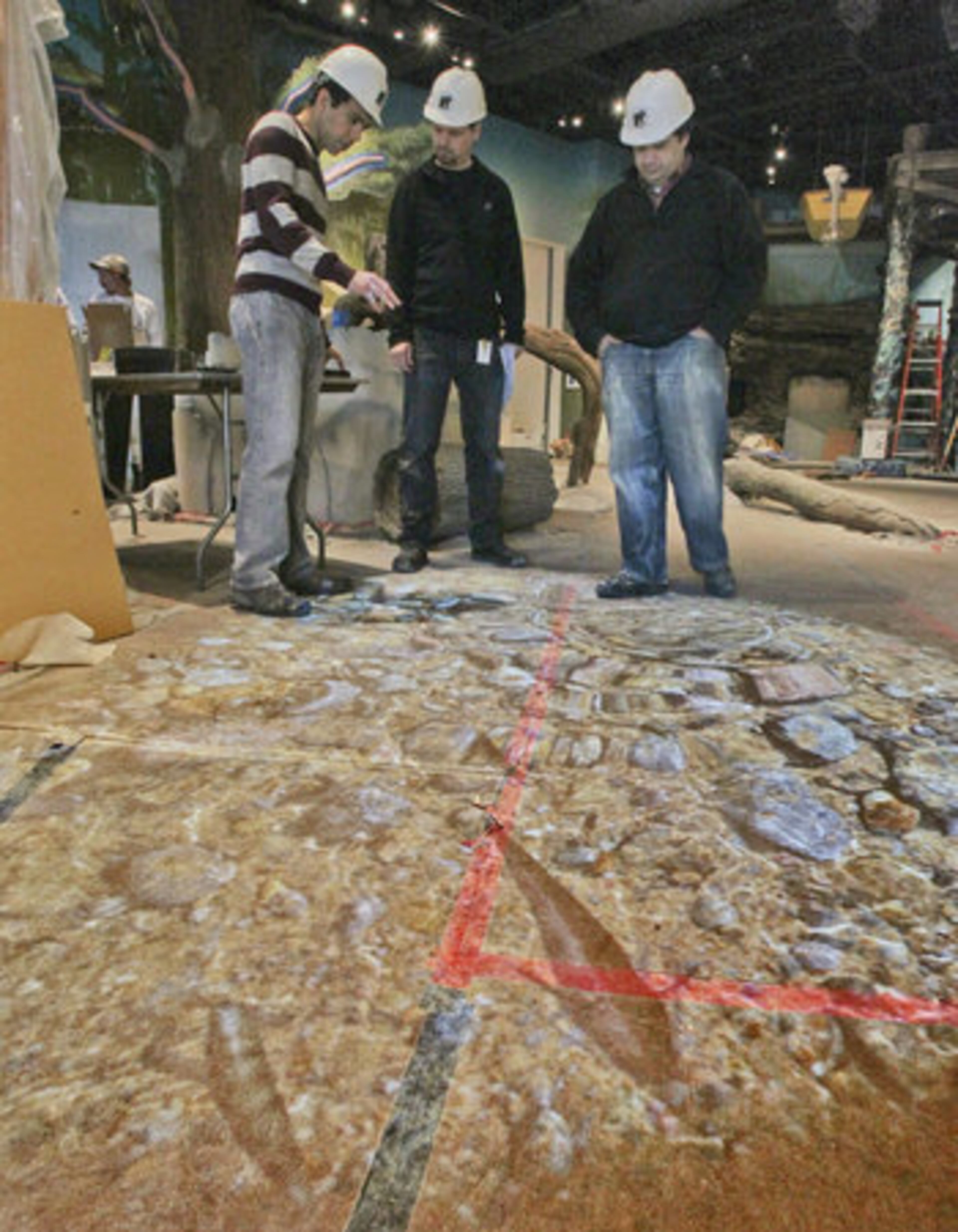 Design team members Vikram Kirby, Chris Hawkes and Gene Rogers work with the Gesture Tek Ground FX system that will project an animated river filled with swimming fish.