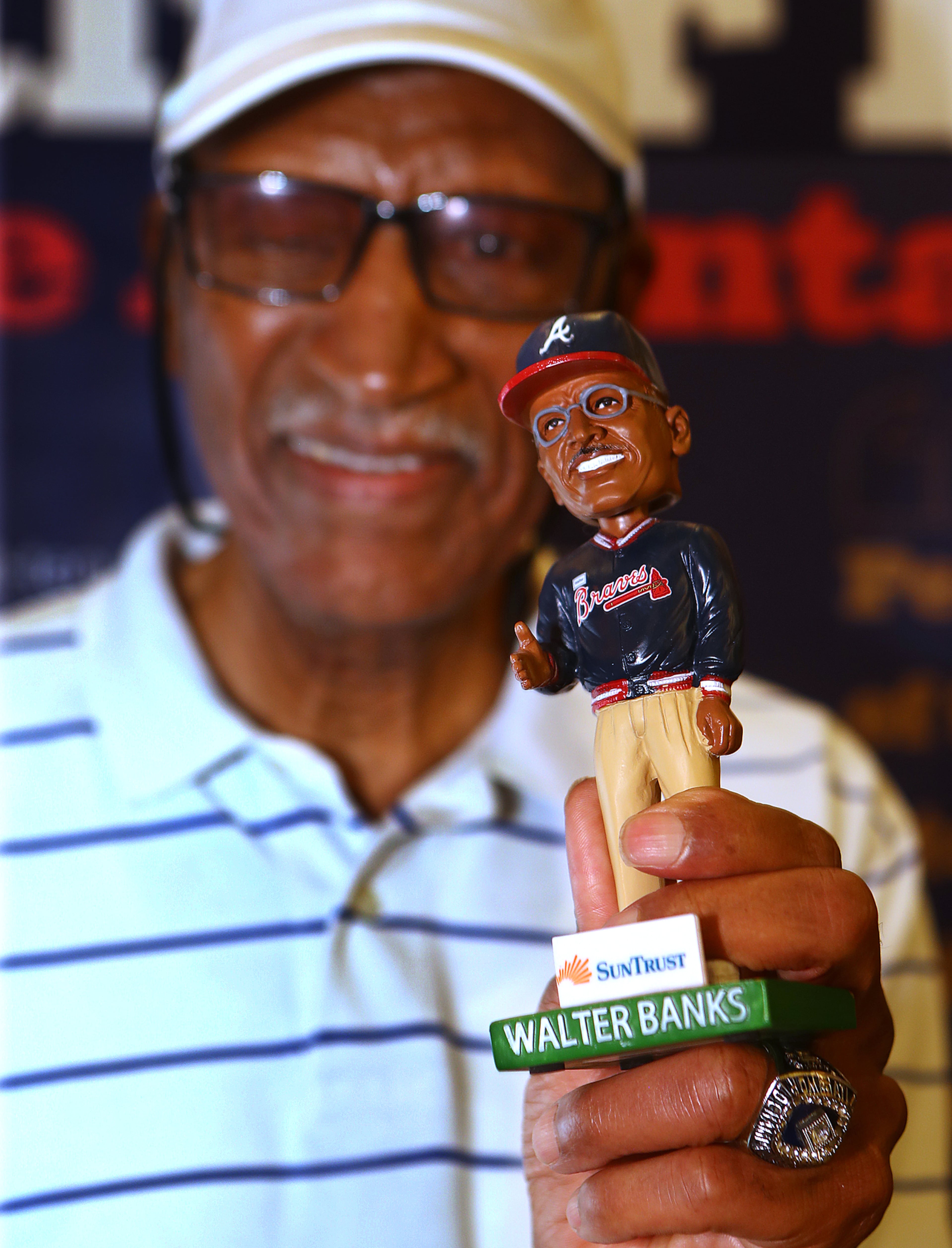 Walter Banks shows off his bobblehead doll during his 80th birthday celebration Monday. (Curtis Compton/ccompton@ajc.com)