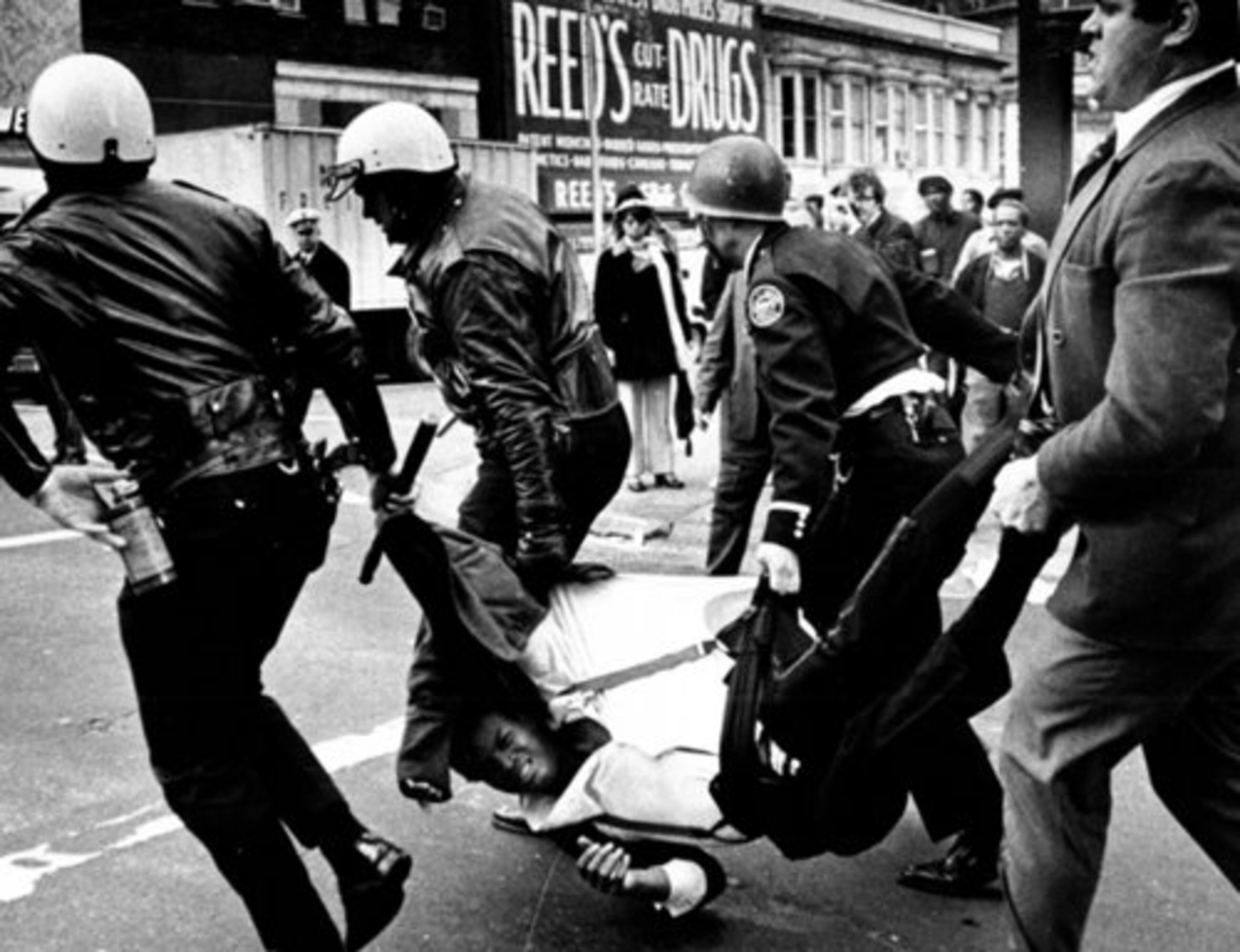A man is carried off by Atlanta Police during a downtown street fight in 1971.
