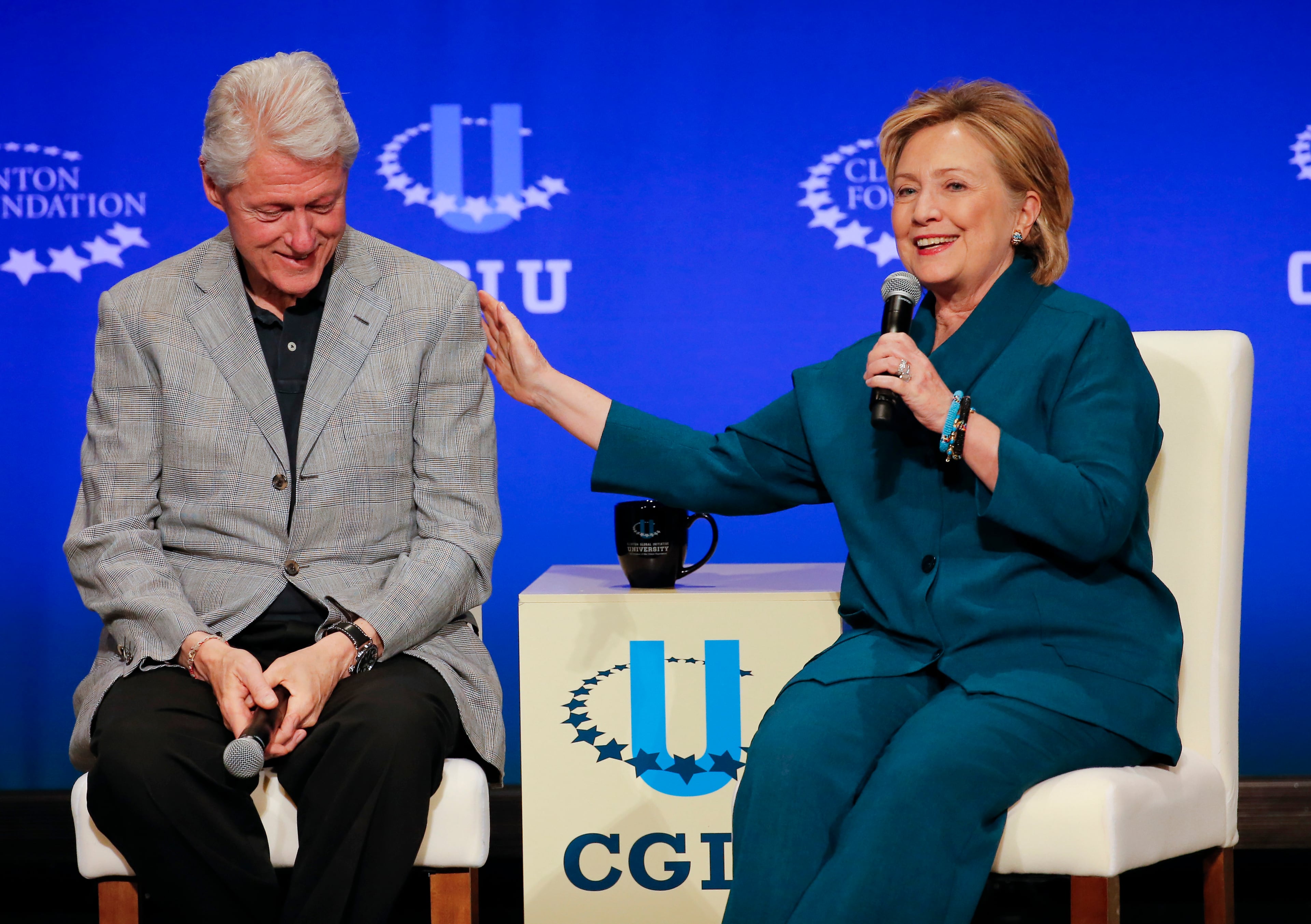 In this March 22, 2014, file photo, former President Bill Clinton, left, listens as former Secretary of State Hillary Rodham Clinton speaks during a student conference for the Clinton Global Initiative University at Arizona State University in Tempe, Ariz. Clinton had long ago moved on from her bruising defeat in her 2008 presidential run. Clinton questioned whether the country was willing to give her family the White House for the third time. A less talked about concern was health, both hers and her husbands. The former president had undergone quadruple bypass surgery and had to make drastic lifestyle changes. Hillary Clinton would be 69 years old on Election Day, tying Ronald Reagan as the oldest American to be elected president if she won. (AP Photo/Matt York, File)