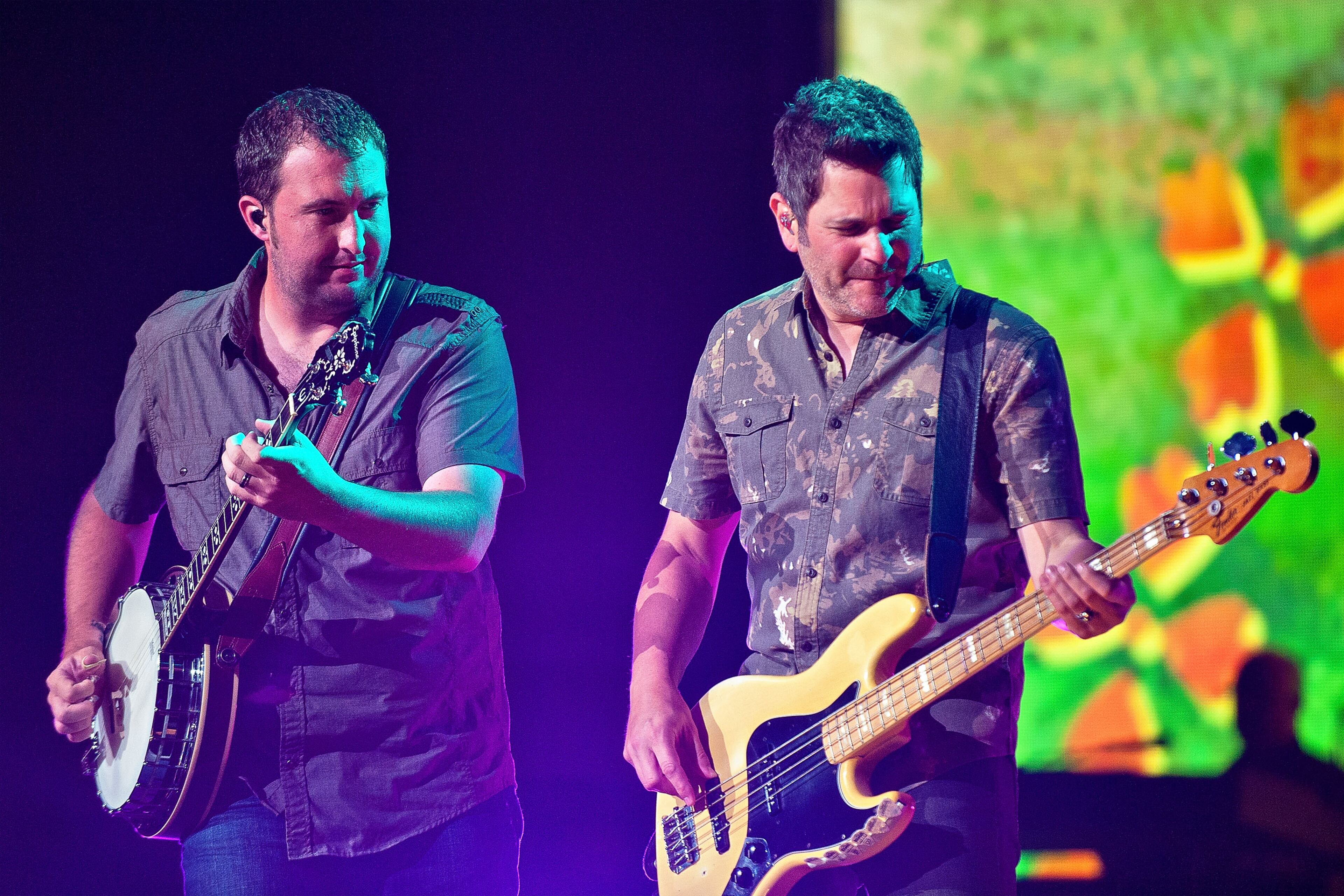 Travis Toy and Jay DeMarcus of the American country music group Rascal Flatts perform at First Midwest Bank Amphitheatre on August 17, 2013 in Tinley Park, Illinois.