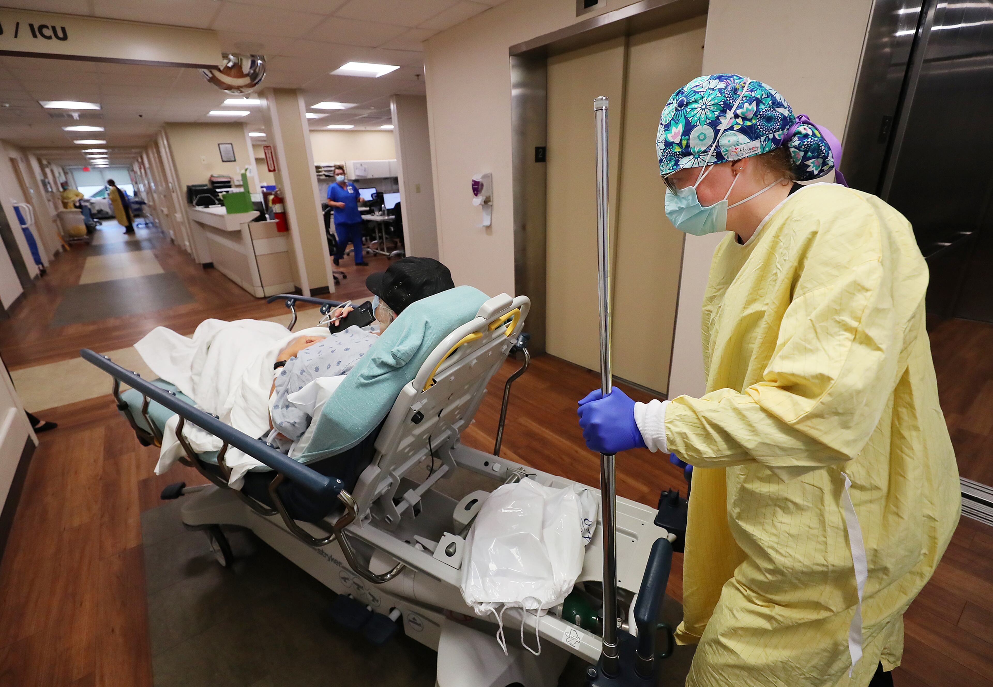 Nurse Carey Mullis moves a COVID patient from the emergency room to a room on a COVID floor at Colquitt Regional Medical Center. Mullis believes she was put on this earth to nurse. She's won awards at it. But she sees her colleagues leaving, worn down by the constant deaths, and wonders if she might leave, too. (Curtis Compton / Curtis.Compton@ajc.com)