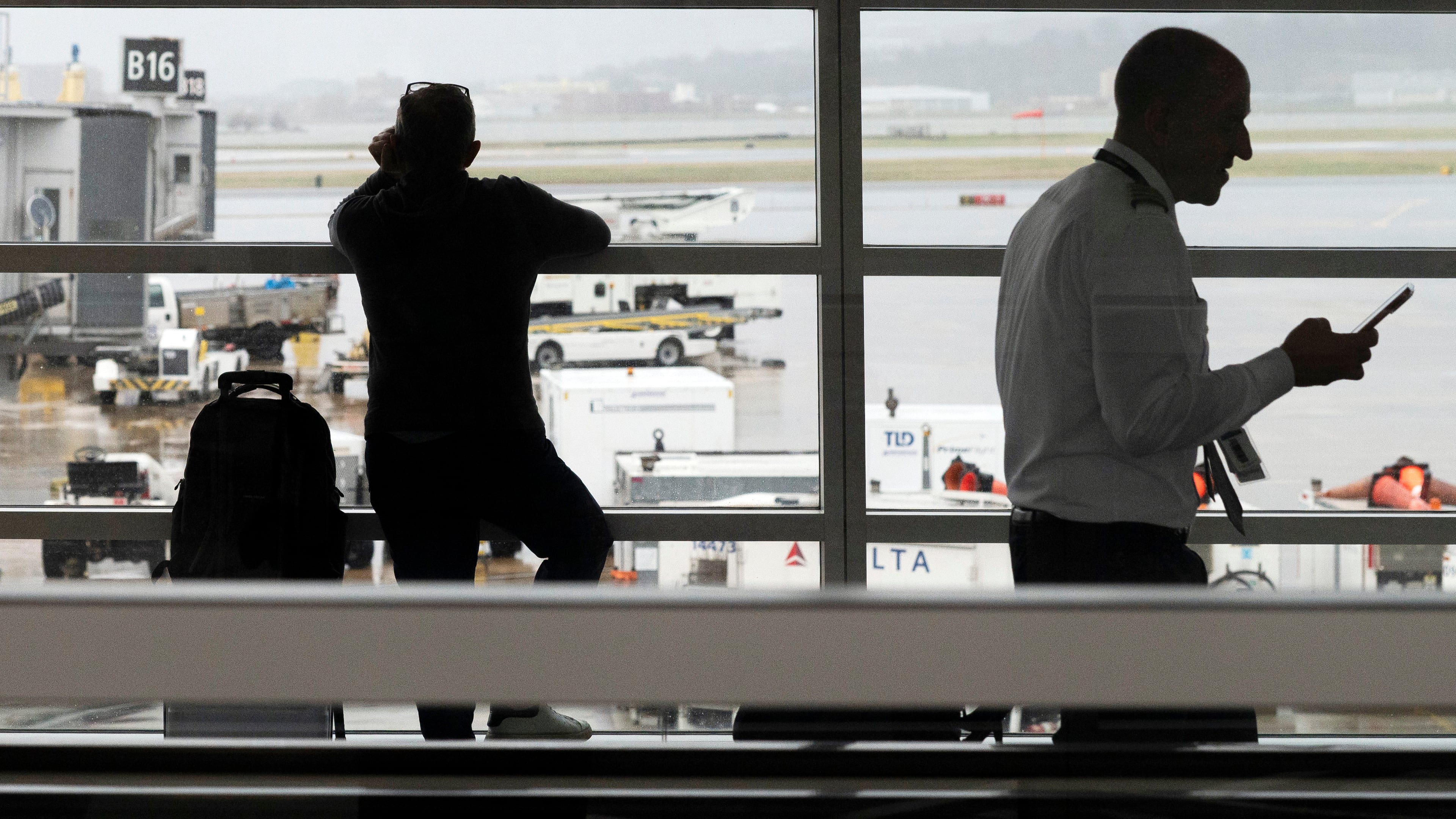 People wait in a departure terminal at Ronald Reagan National Airport, in Arlington, Va., Monday, March 16, 2026. (AP Photo/Cliff Owen)