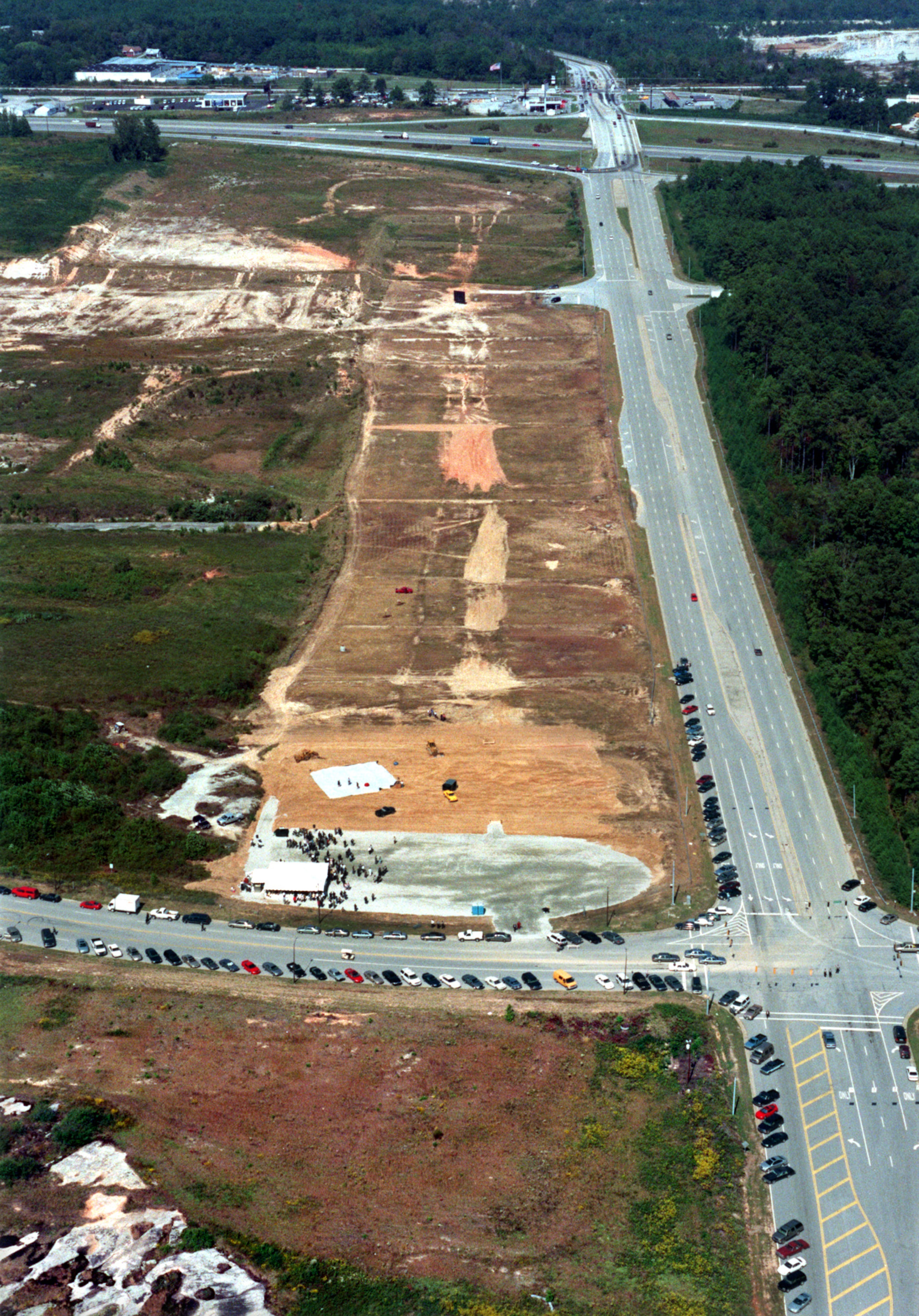 991007 LITHONIA, GA.:--FINALLY A GROUNDBREAKING--Cars line the Mall Parkway at Turner Hill Road during the groundbreaking ceremony for the long delayed mall in Lithonia on Thursday, Oct. 7, 1999. The Mall at Stonecrest has sat undeveloped for 16 years until today. I-20 is in the background at the Turner Hill Road intersection. (CURTIS COMPTON/staff)