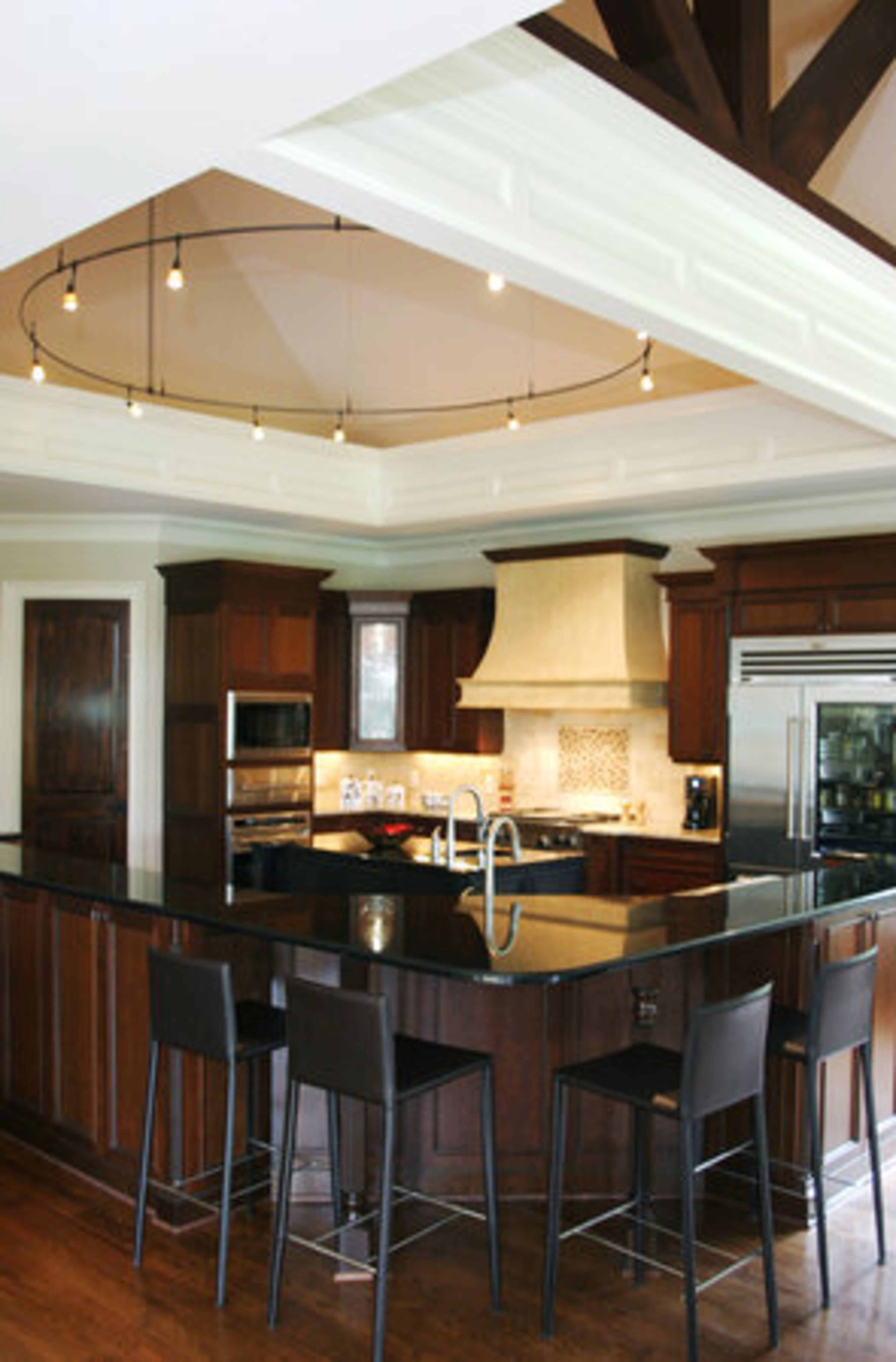 The kitchen has double islands and dishwashers, two double ovens and Wolf and a Sub Zero 48" glass-front refrigerator. The custom light fixture set in the vaulted ceiling is from C Lighting. "It's a little bit off the cuff," adds interior designer Rhonda Feldman.