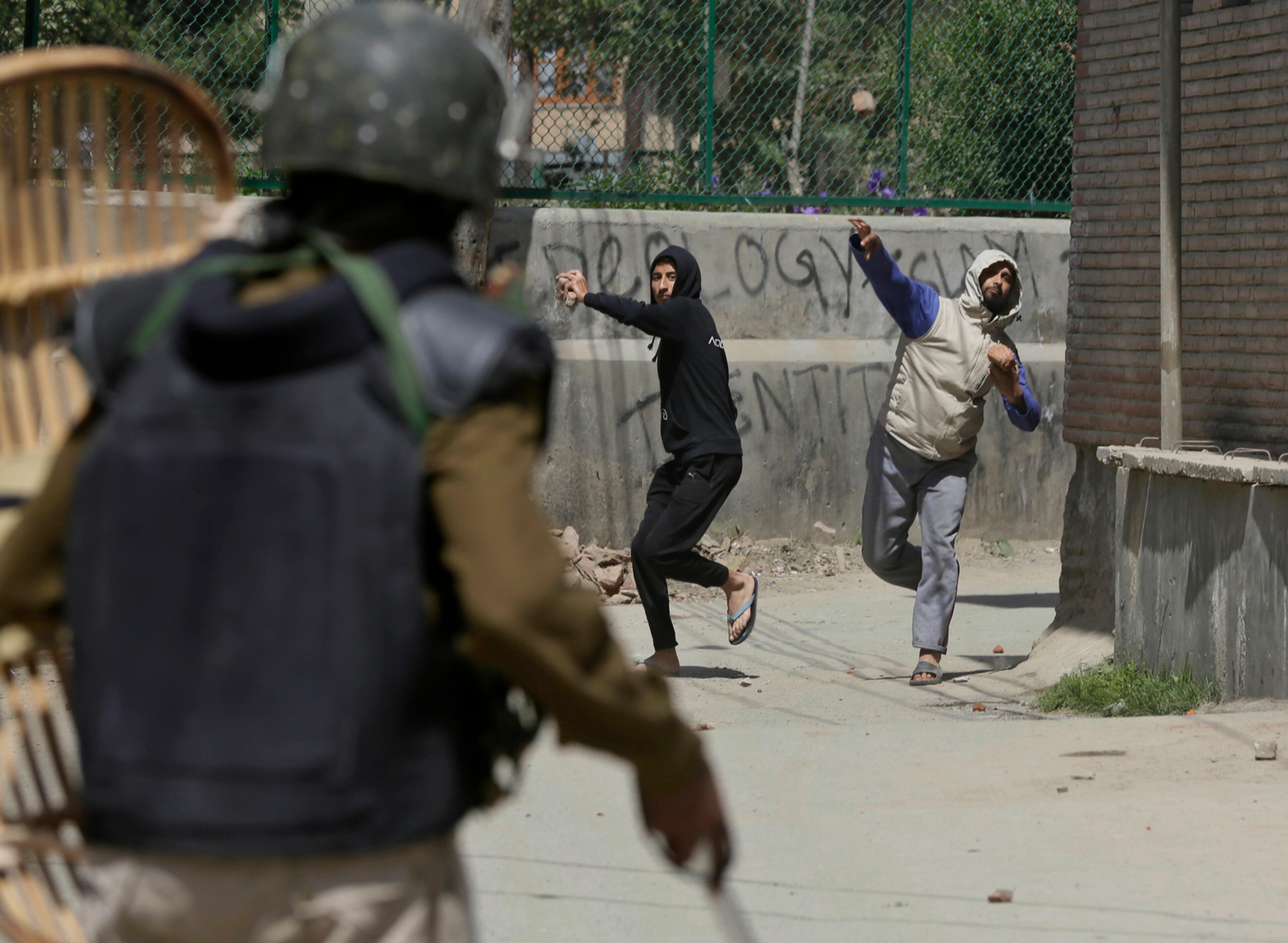 Kashmiri protesters throw stones on Indian paramilitary soldiers during a protest in Srinagar, Indian controlled Kashmir, Sunday, April 16, 2017. Kashmiri separatists called for a strike Sunday to protest against the killing of a teenage boy who died Saturday when government soldiers fired at a group of young men who threw stones at them. (AP Photo/Mukhtar Khan)