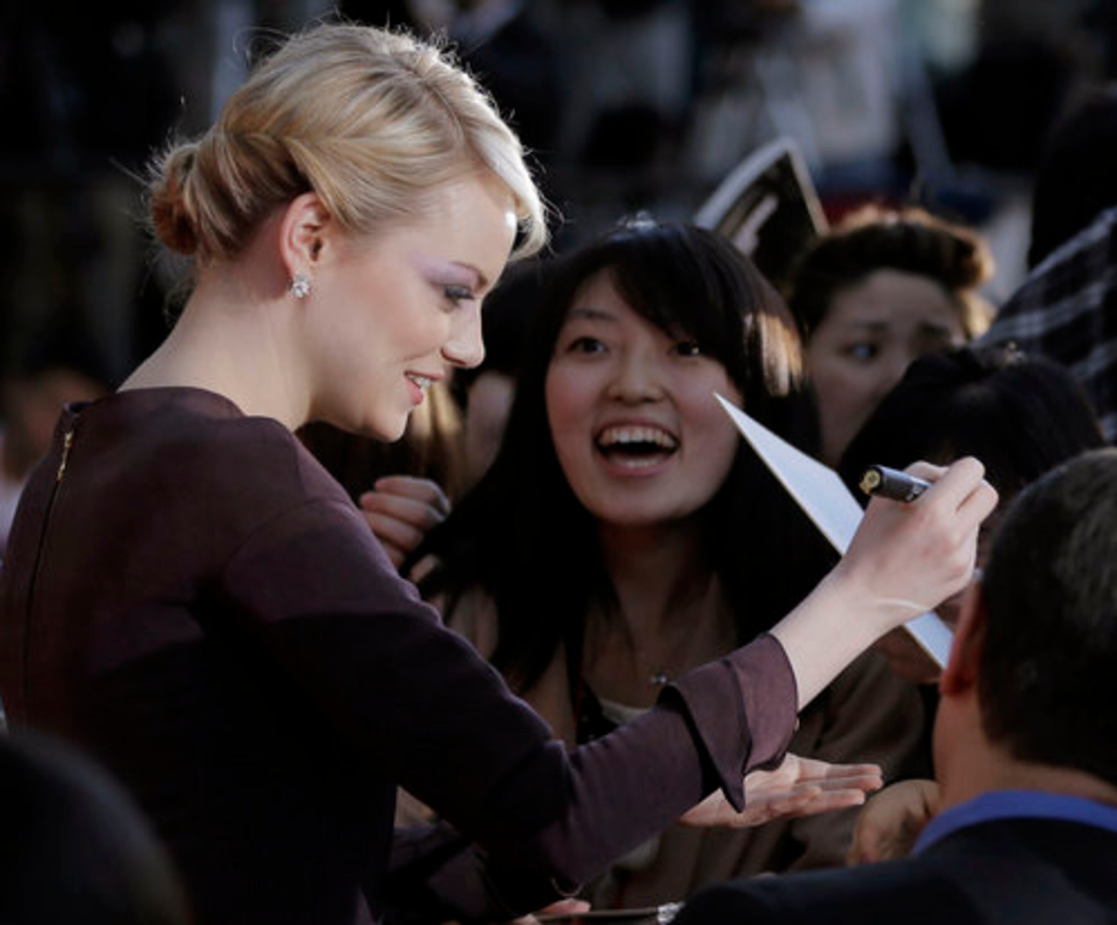 Emma Stone, who portrays Peter Parker love interest Gwen Stacy in "The Amazing Spider-Man" signs autographs.