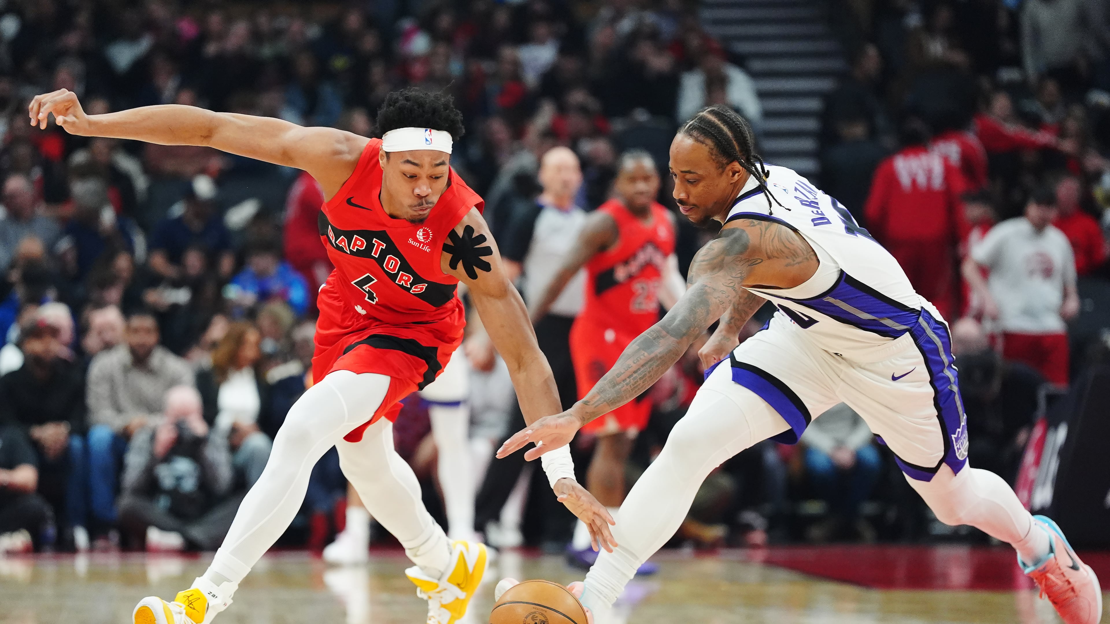 Toronto Raptors' Scottie Barnes (4) and Sacramento Kings' DeMar DeRozan (10) battle for the ball during the first half of an NBA basketball game in Toronto, Wednesday, April 1, 2026. (Frank Gunn/The Canadian Press via AP)