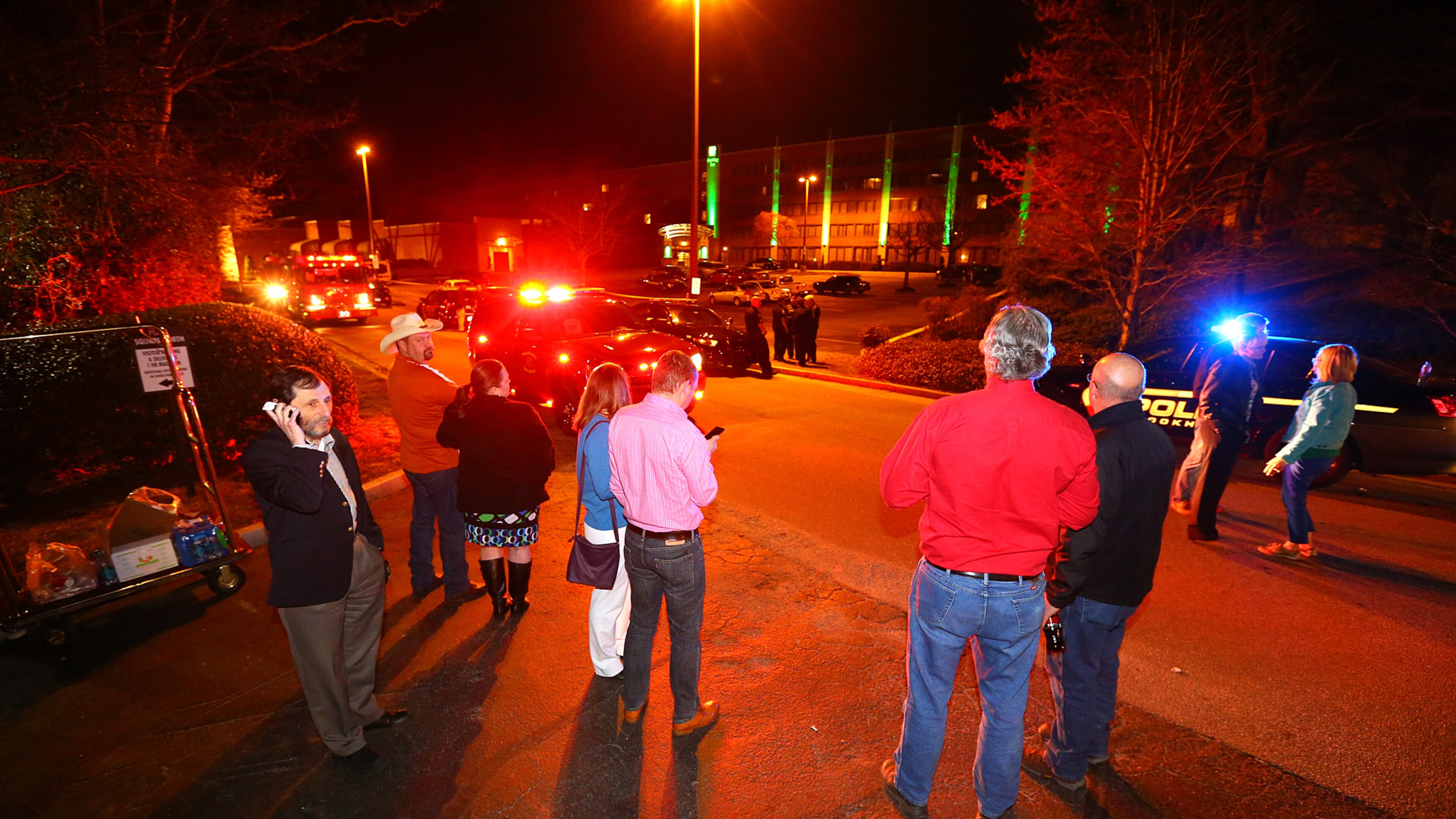 Evacuated guests wait in the street at the Holiday Inn on Chamblee Dunwoody Road while the DeKalb County bomb squad investigates a suspicious device on Thursday, March 20, 2014, in Atlanta. Four individuals have been taken into custody during an investigation into drug activity with narcotics, a weapon, and a suspicious device found on the scene. CURTIS COMPTON / CCOMPTON@AJC.COM