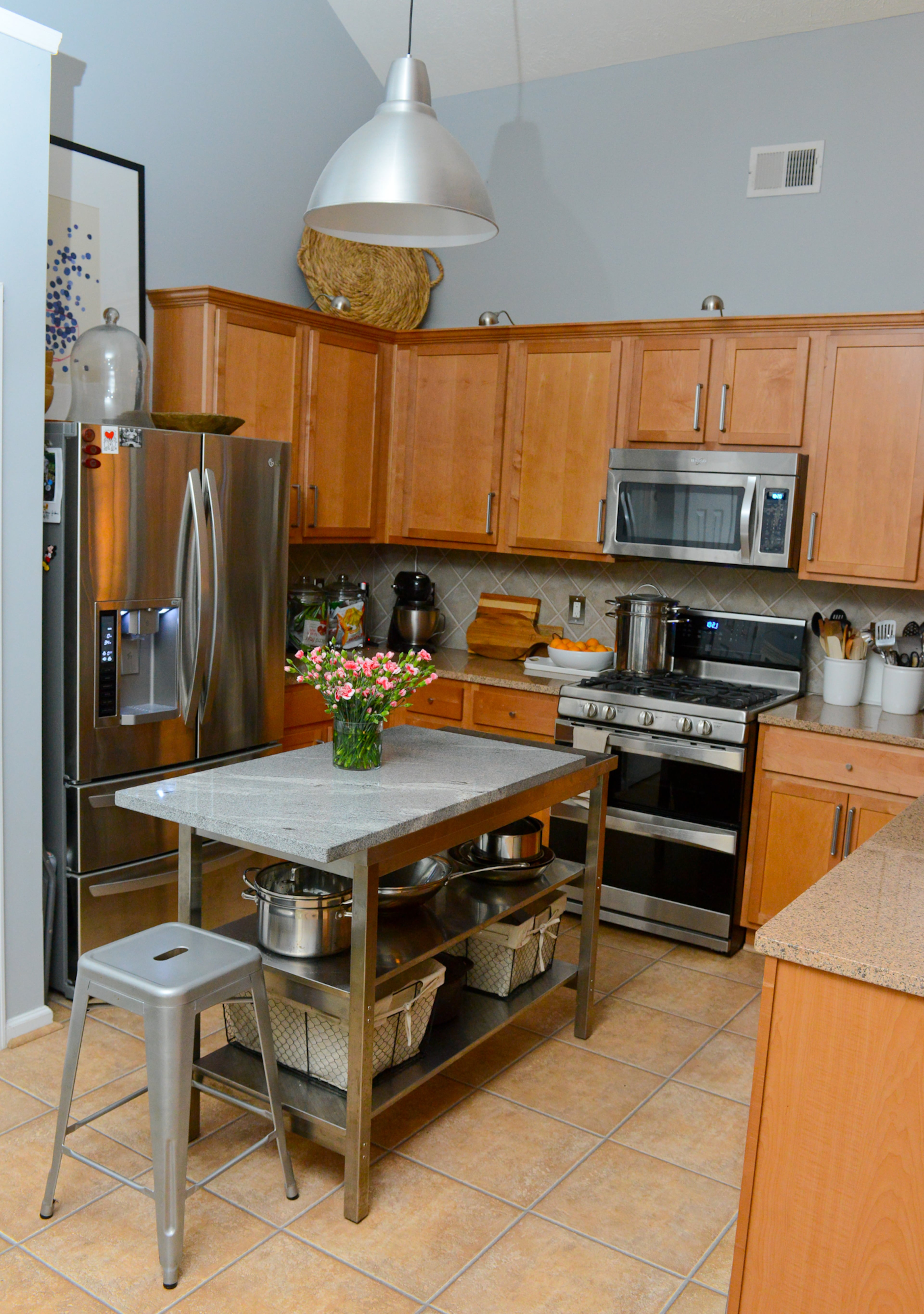 Craig Cowan and Travis Snyder added an island from Ikea with a custom countertop in the kitchen of their 2004 Union City home. The homeowners also brought in artwork from Etsy to balance the stainless steel appliances and light wood cabinets.
