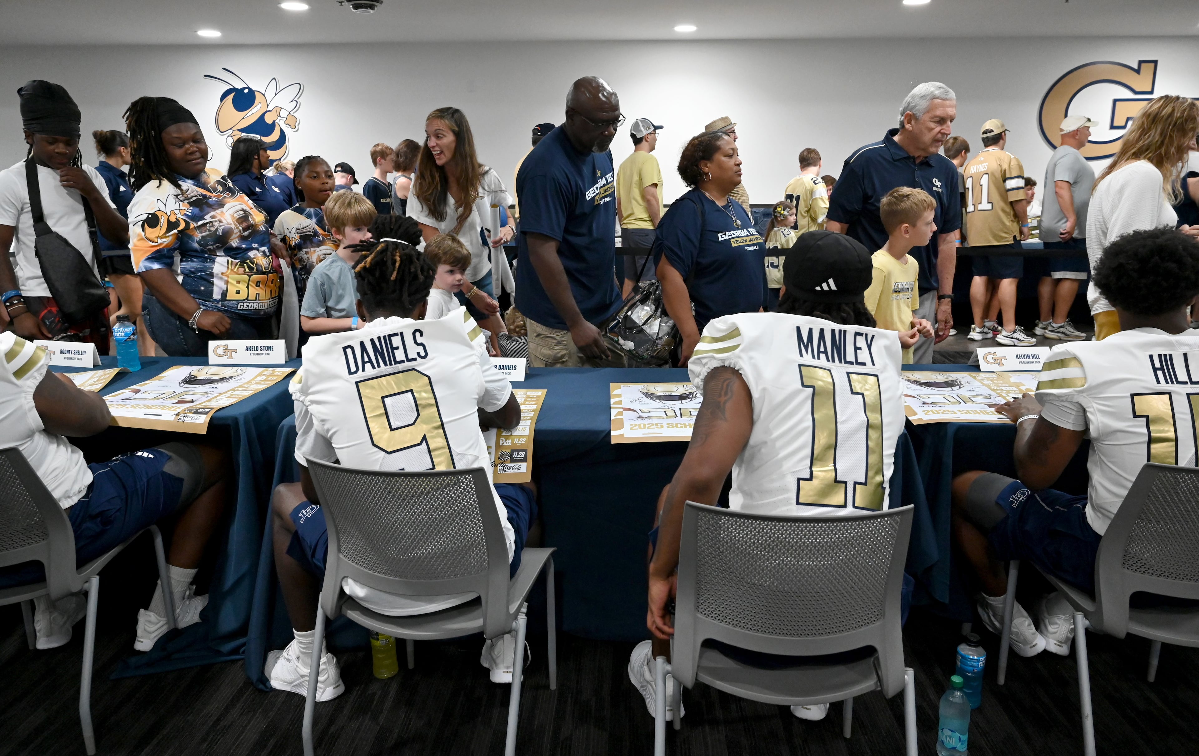 Georgia Tech football players sign autographs for event attendees during the annual “First Saturday on The Flats” at Bobby Dodd Stadium, Saturday, August 2, 2025, in Atlanta. The Flats provides Tech fans with the opportunity to engage with their favorite Yellow Jackets ahead of the upcoming 2025 season. The event offers a variety of entertaining activities for the whole family, including a DJ, autograph opportunities, tailgate games and interactive experiences right on the field at Bobby Dodd Stadium. (Hyosub Shin / AJC)