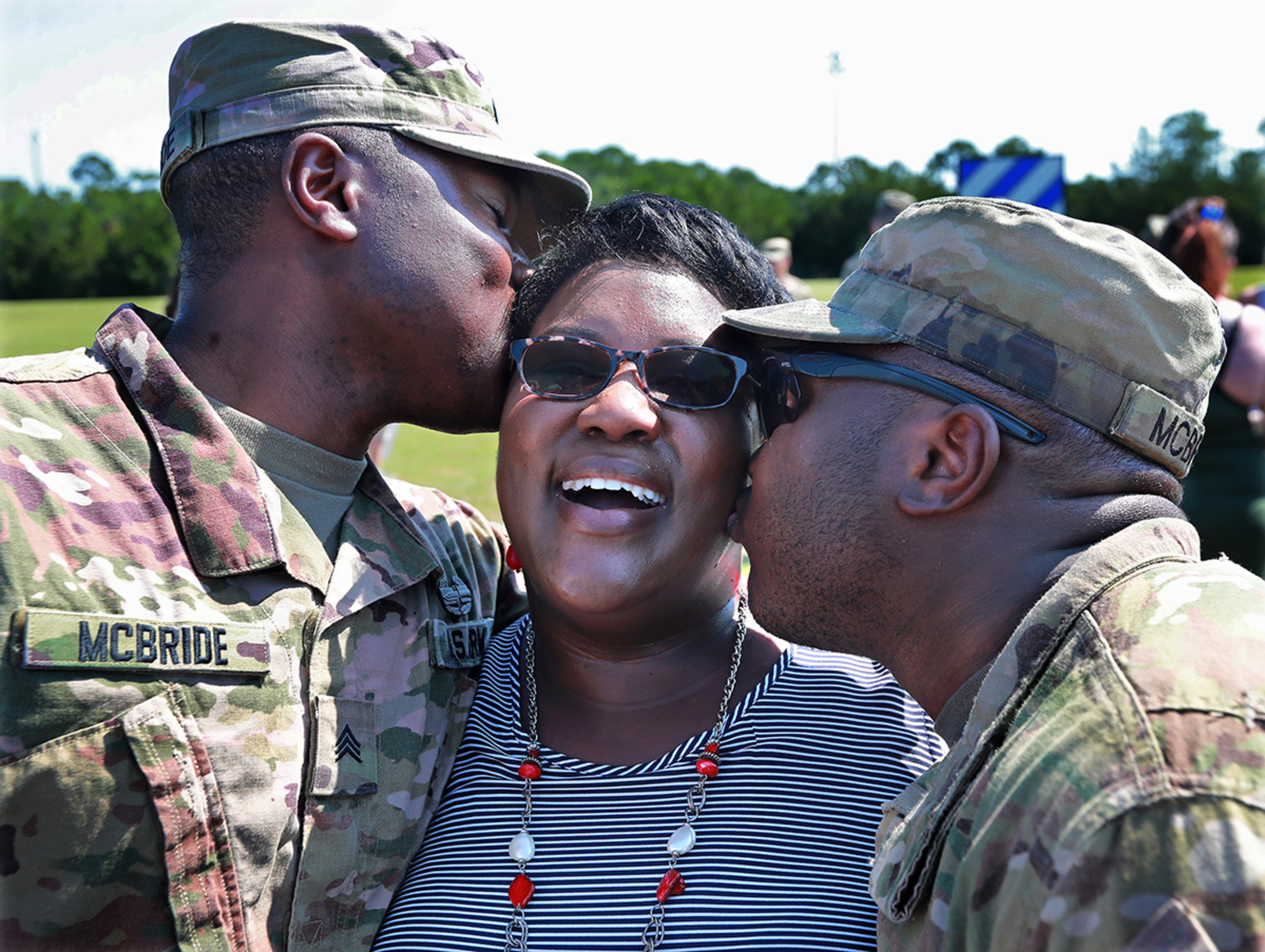 July 30, 2019 Fort Stewart: Fraternal twins Matthew (left) and Ryan McBride embrace their mother Sandra McBride after she rushed the field as soldiers of the 48th Infantry Brigade Combat Team representing units from across the state return home from deployment to Afghanistan in support of Operation Resolute Support at Cottrell Field on Tuesday, July 30, 2019, in Fort Stewart. Matthew and Ryan McBride were born just 45 seconds apart and have remained close ever since. Curtis Compton/ccompton@ajc.com