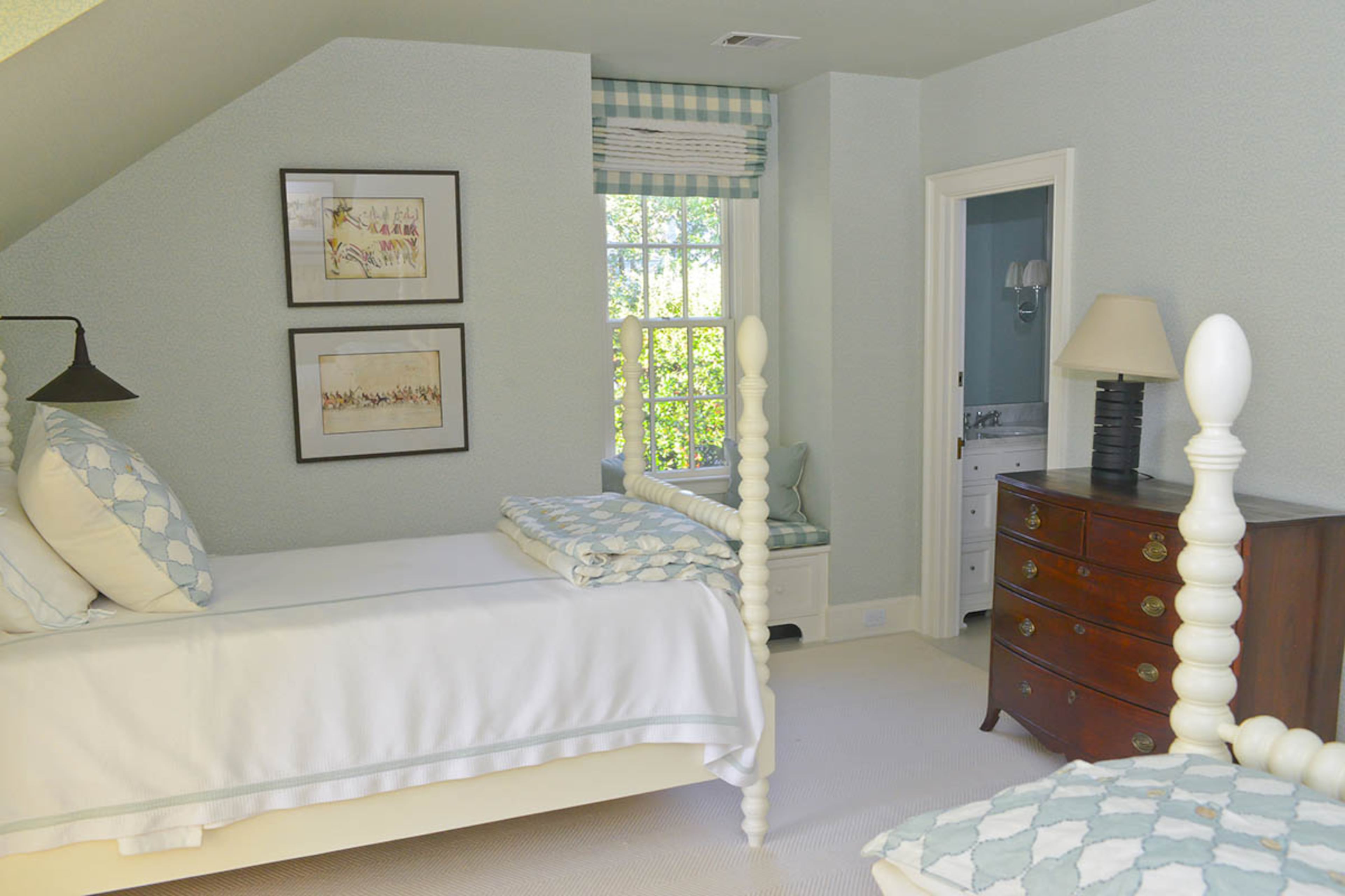 Spindle beds give an upstairs bedroom a classic style. The Currey & Co. wall sconces and Native American-themed art were selected by interior designer Jacquelynne P. Lanham.