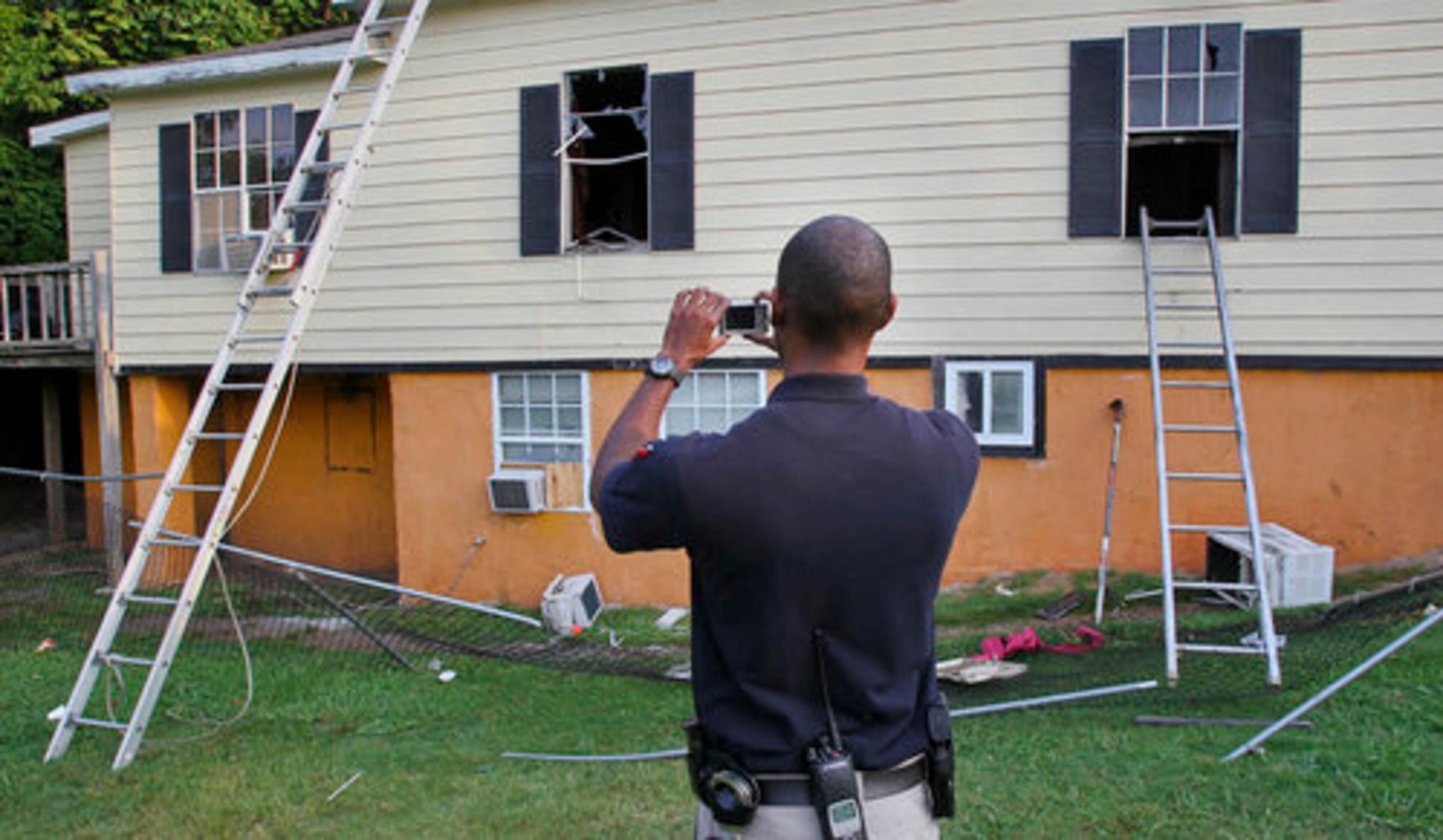 Atlanta fire investigator Lt. D.B. Dabney takes pictures of the outside of the house where the rescue took place. Fire officials said the blaze, which was possibly a cooking fire that got out of hand, damaged about 80 percent of the structure.