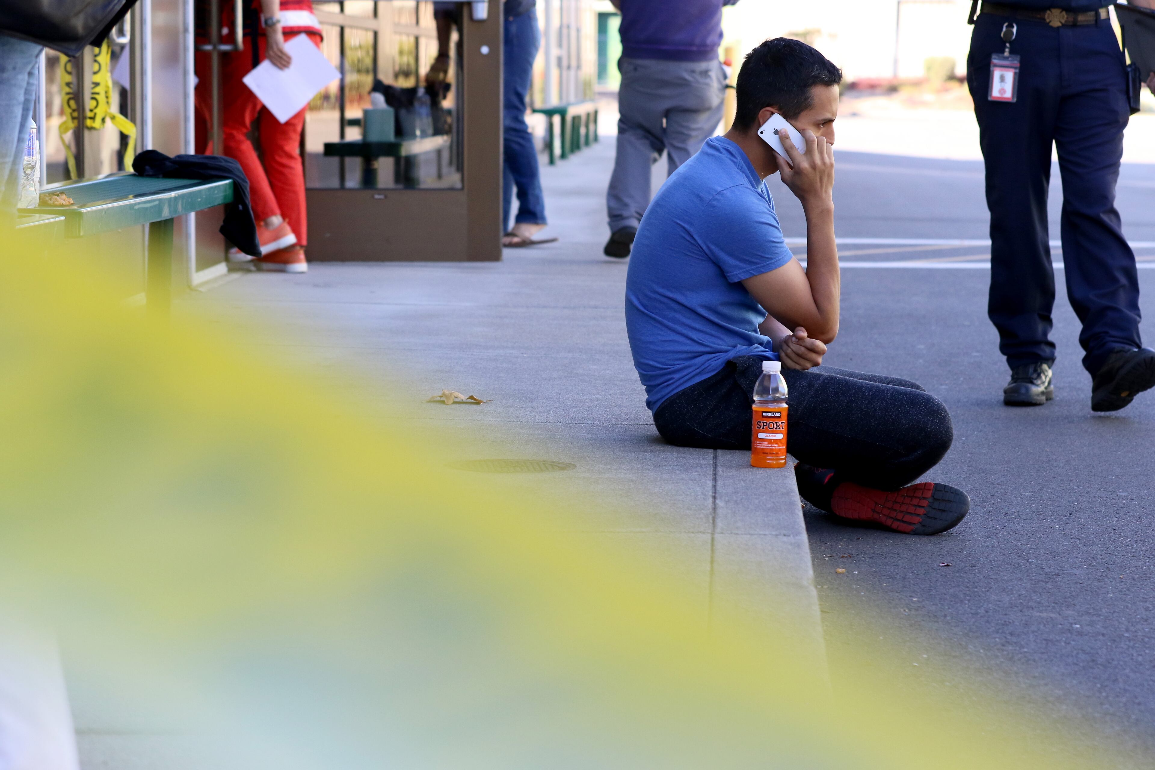 A young man uses his cellphone at the county fairgrounds in Roseburg, Ore., Thursday, Oct. 1, 2015, following a deadly shooting at nearby Umpqua Community College. Students and faculty were bused to the fairgrounds where counselors were available and some parents waited for their children. (AP Photo/Ryan Kang)
