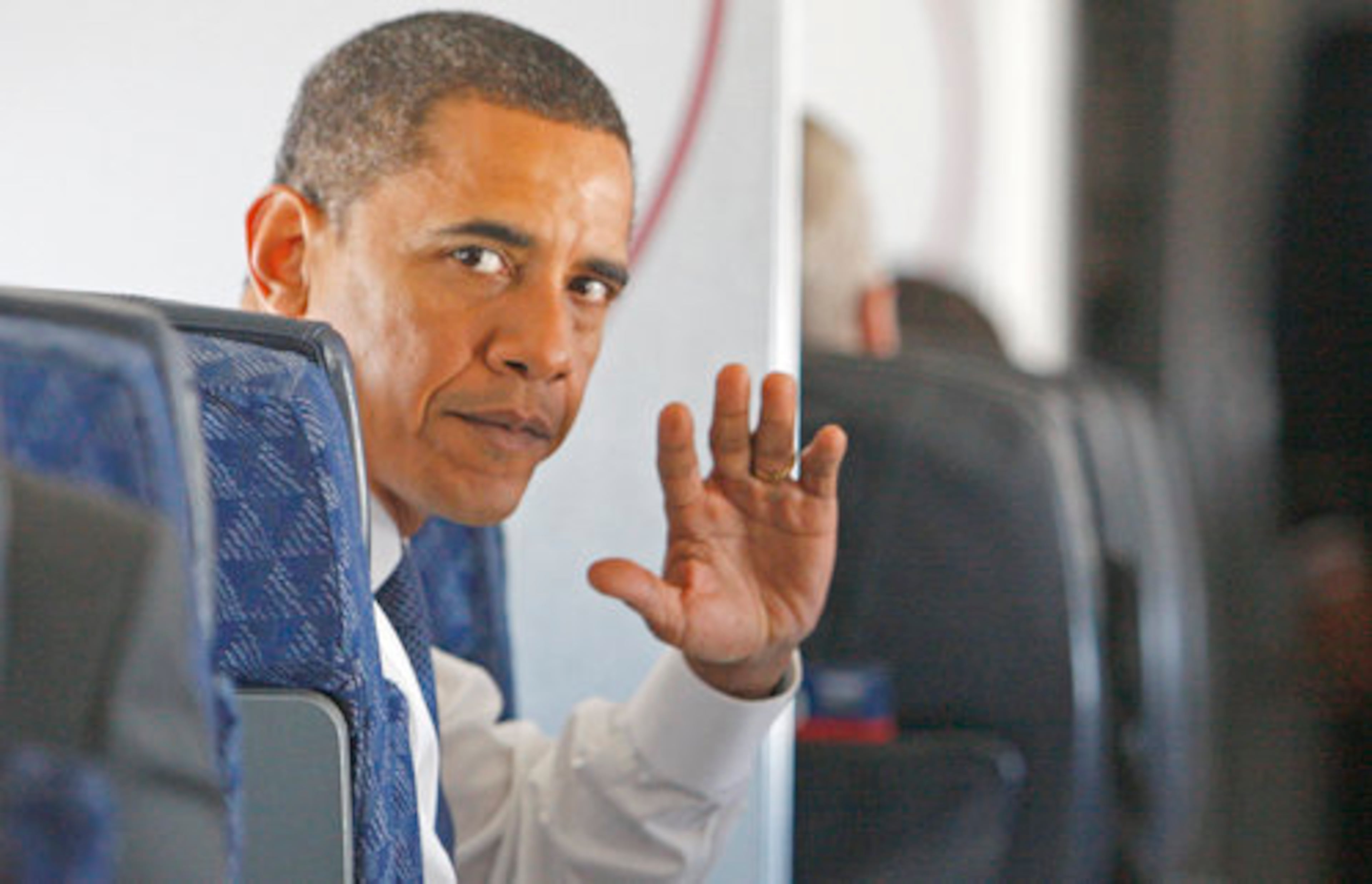 President-elect Obama waves to a reporter on his plane flying from Chicago to Washington D.C.