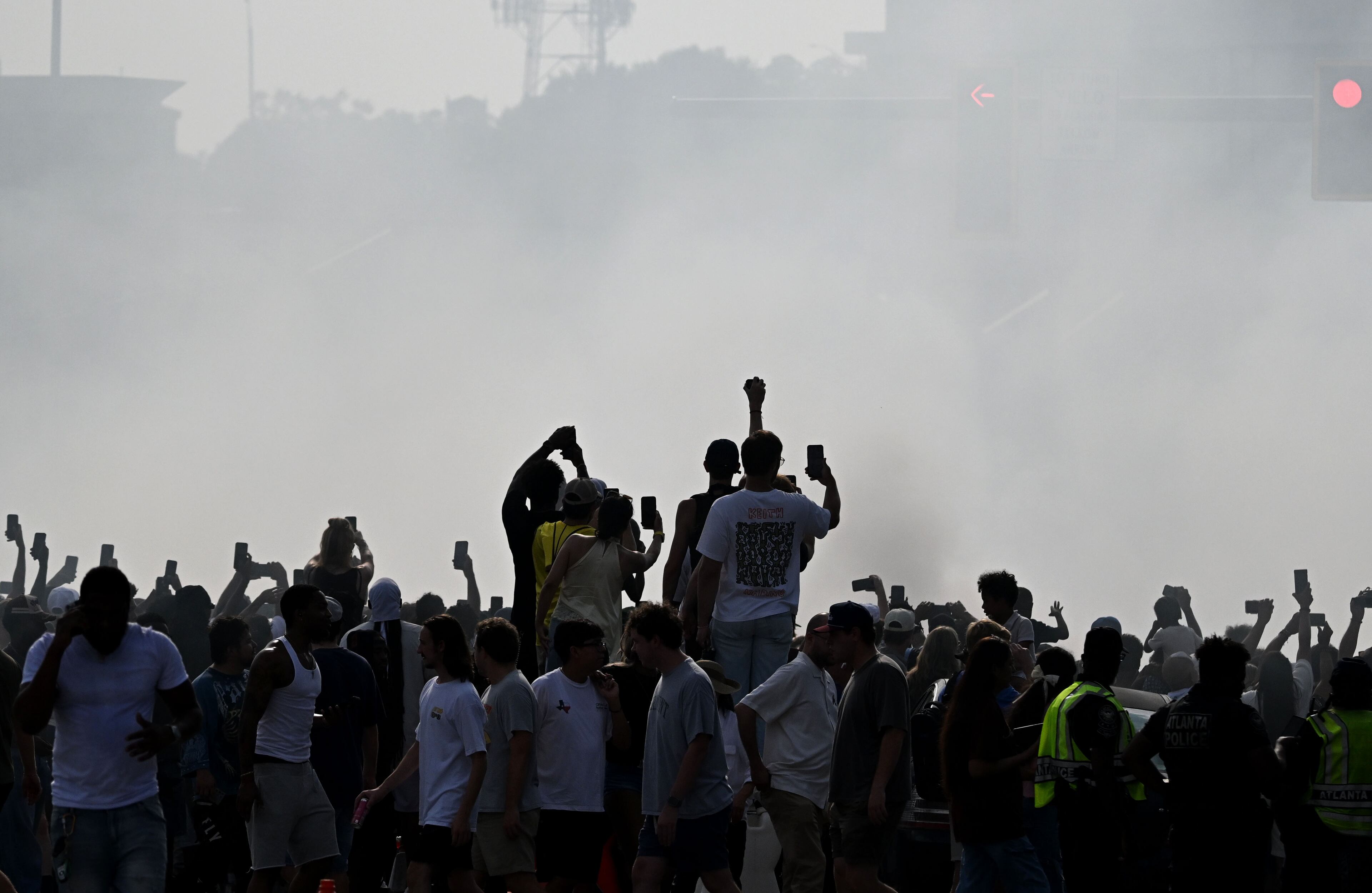 Spectators hold up their smartphones to capture a demonstration run on Hank Aaron Drive during the Red Bull Showrun Atlanta Presented by Ford Racing on Saturday, Aug. 1, 2026, in Atlanta. Atlanta city officials this week approved permits for the Red Bull Showrun that will allow the live motorsports demonstration event to go on as advertised along a roughly half-mile stretch of Hank Aaron Drive — a backup location after earlier plans to hold the event near Piedmont Park ran into opposition from Midtown residents. (Hyosub Shin/AJC)