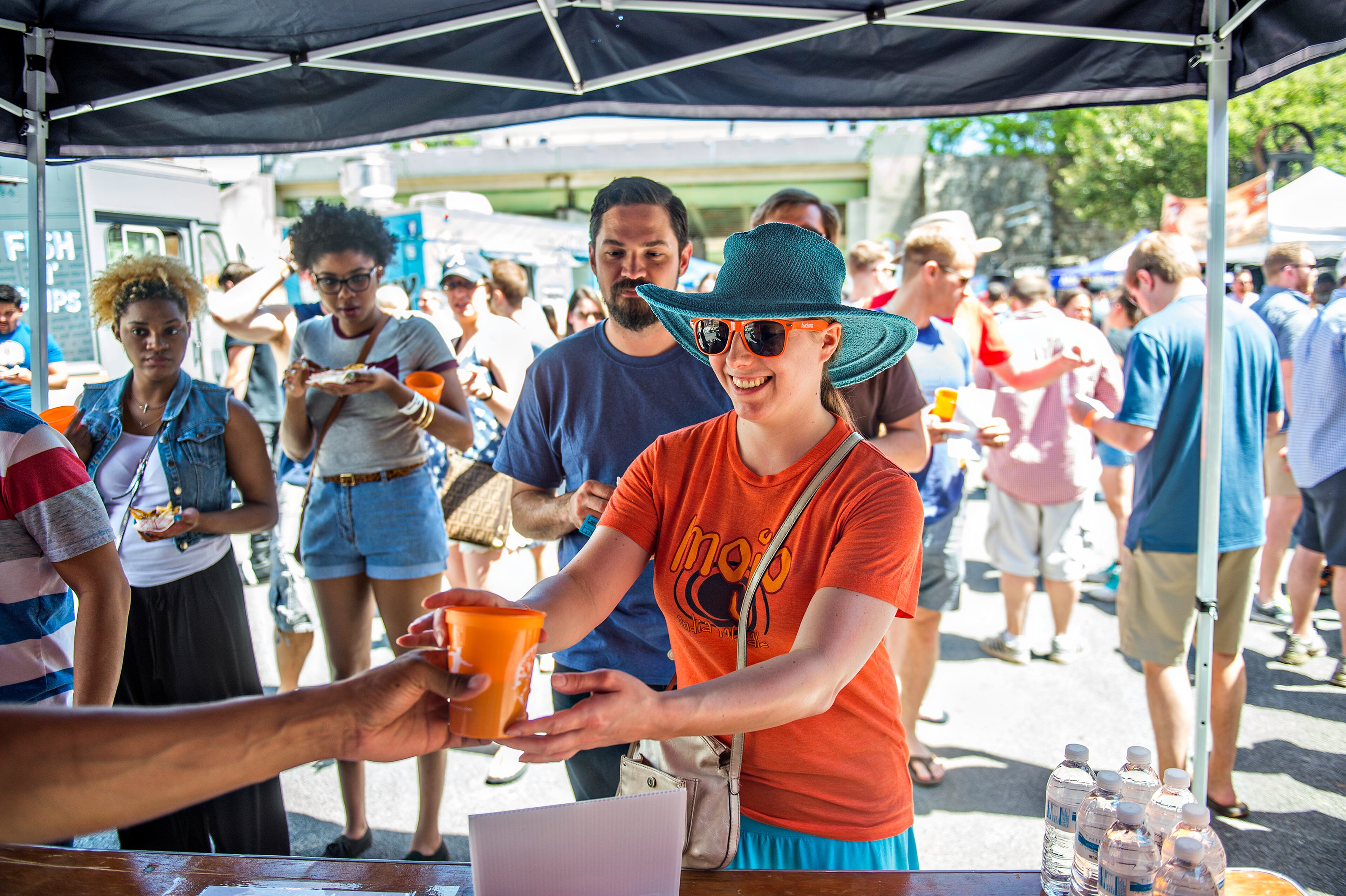 April 11, 2015 Atlanta - Kalyn Kelly (center) reaches for her freshly poured beer during the Hogs & Hops Festival at The Masquerade in Atlanta on Saturday, April 11, 2015. The annual festival featured beer and barbeque as well as live music and games. JONATHAN PHILLIPS / SPECIAL