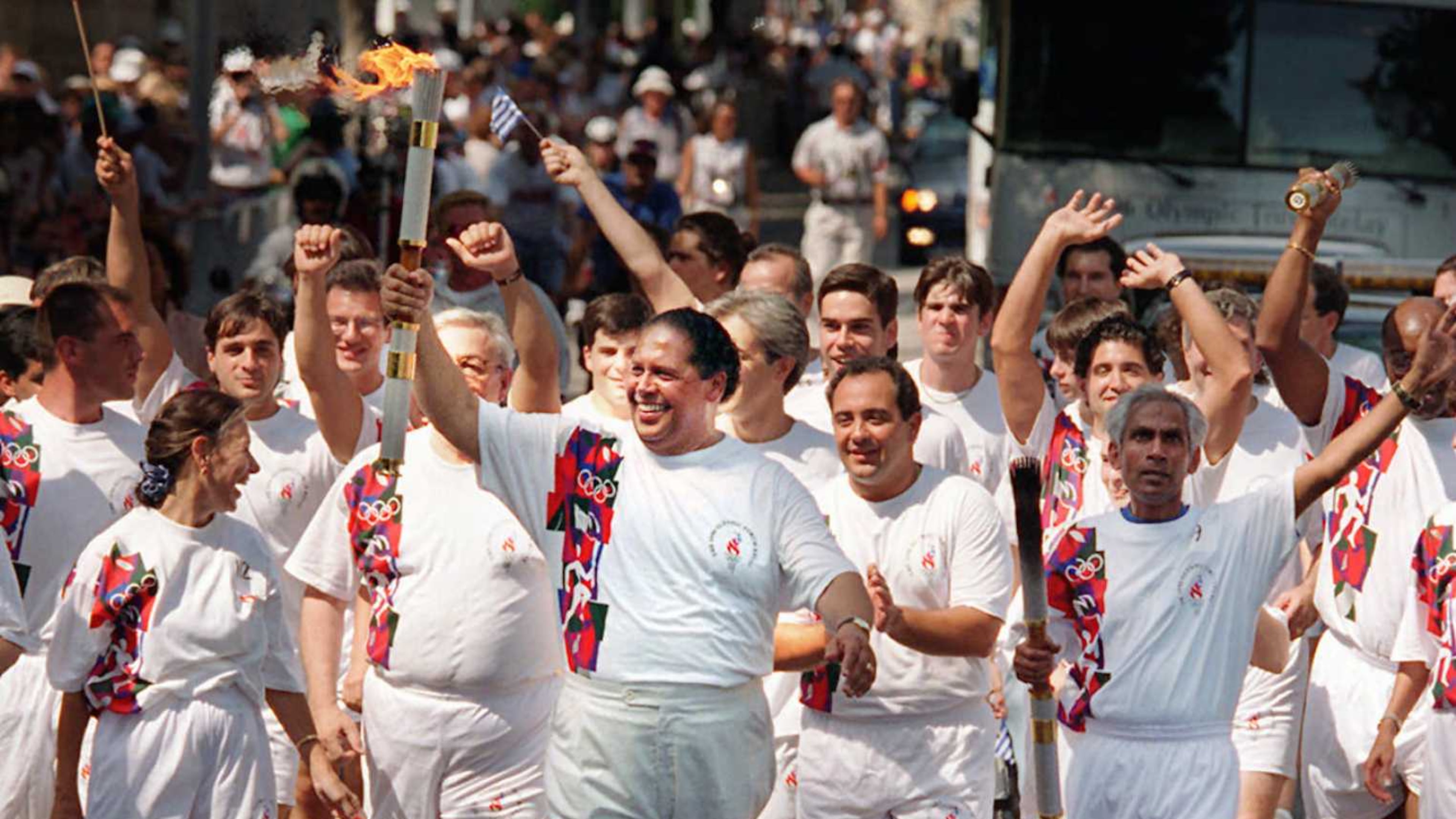 Former Atlanta Mayor Maynard Jackson (center) carries the torch up Washington Street on its way to City Hall on Friday, July 19, 1996, for a final ceremony before heading to the Olympic Stadium for the Opening Ceremonies of the 1996 Summer Olympic Games. (Greg Lovett/Palm Beach Post/Cox Newspapers)