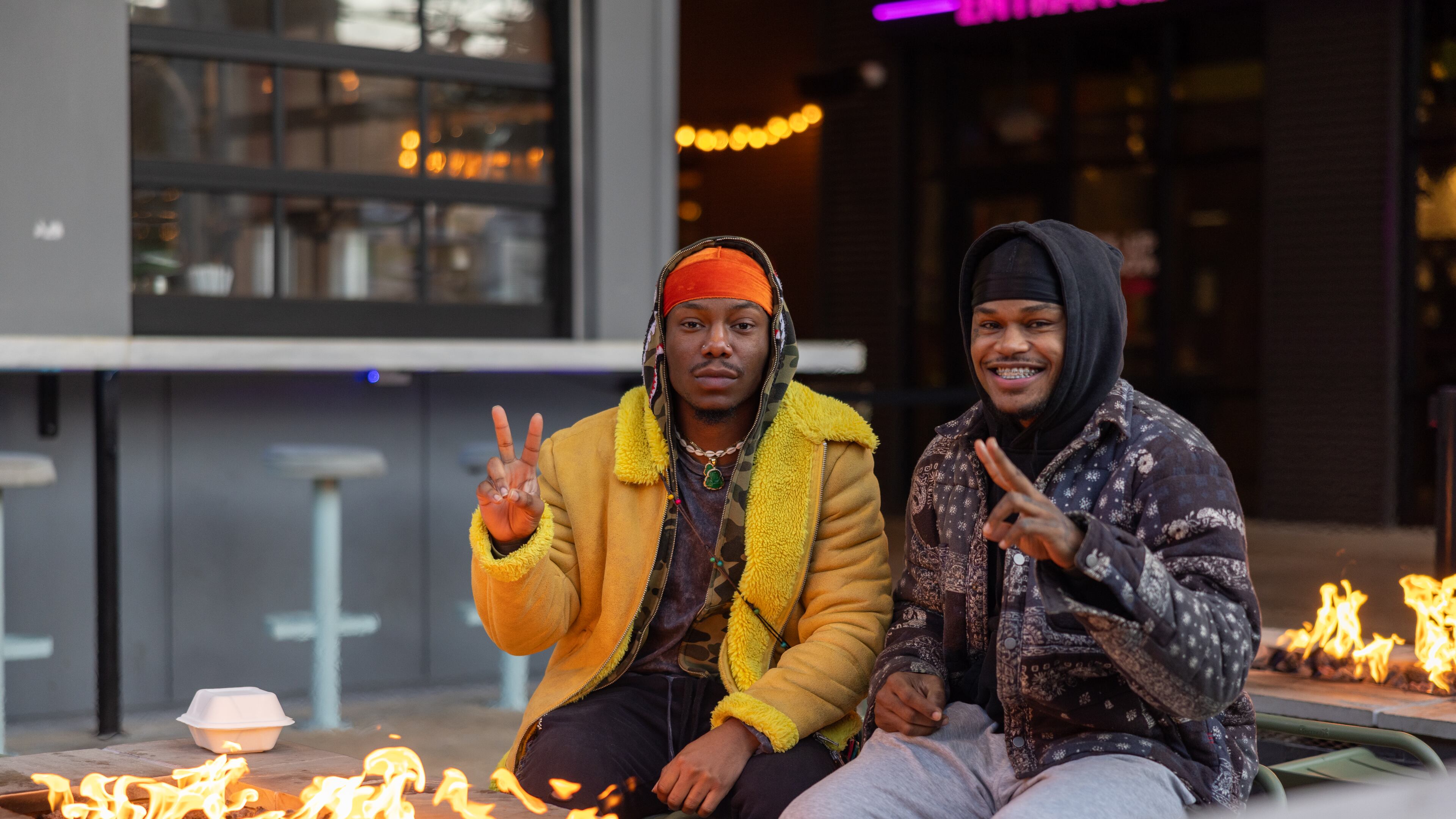 Friends sitting near fire outside of Caffine + Cocktail Bar at West Midtown on November 17, 2022