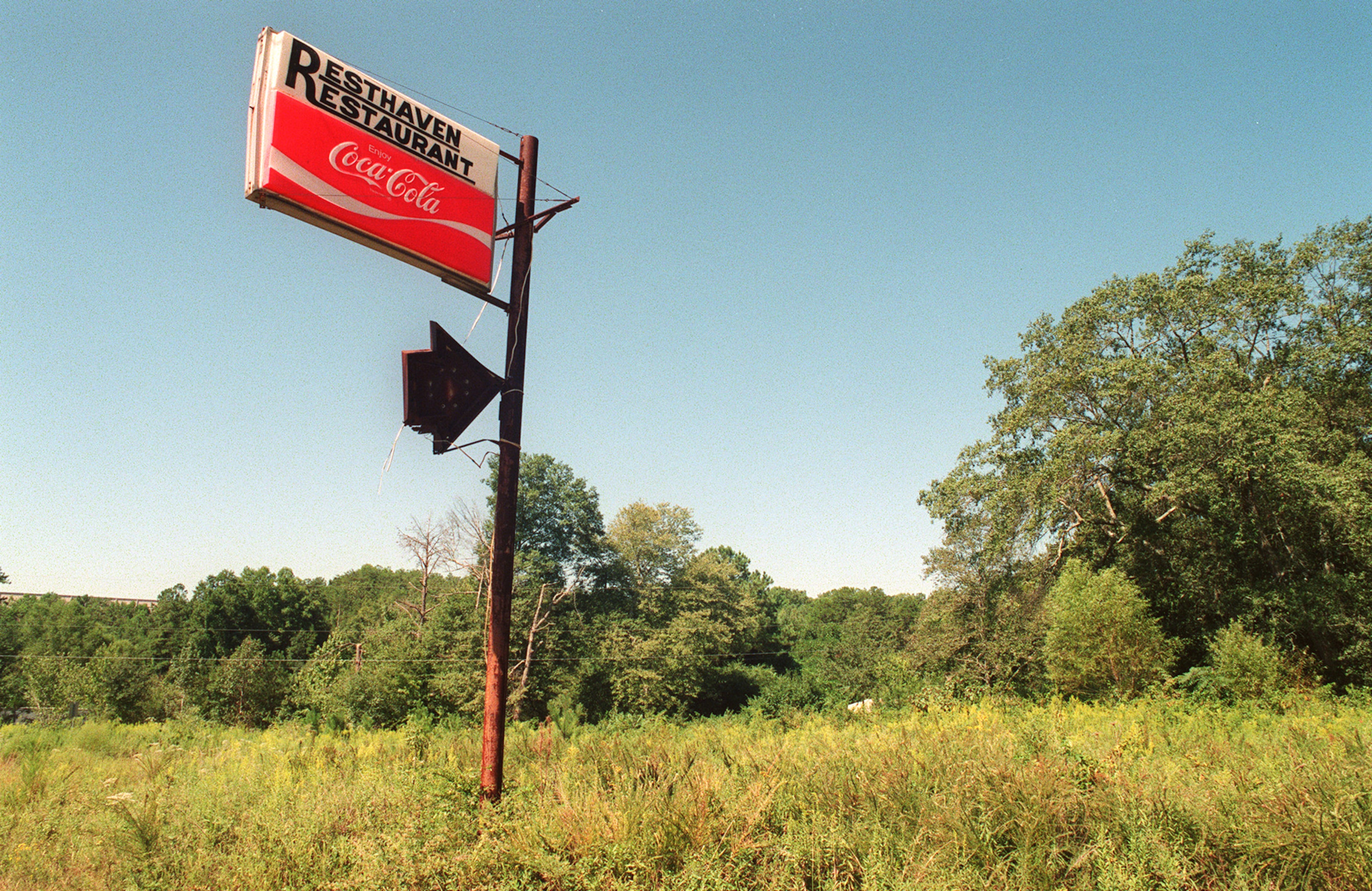 “It was always colorful,” said Lynn Bowman, curator of the Museum of Buford, who as a child passed through Rest Haven on his way to school. “It’s kind of an eyesore, but it’s our eyesore.” This photo from 1998 shows an old sign pointing to the Rest Haven Restaurant, which was already a memory when this photo was taken. (LOUIE FAVORITE / AJC file)