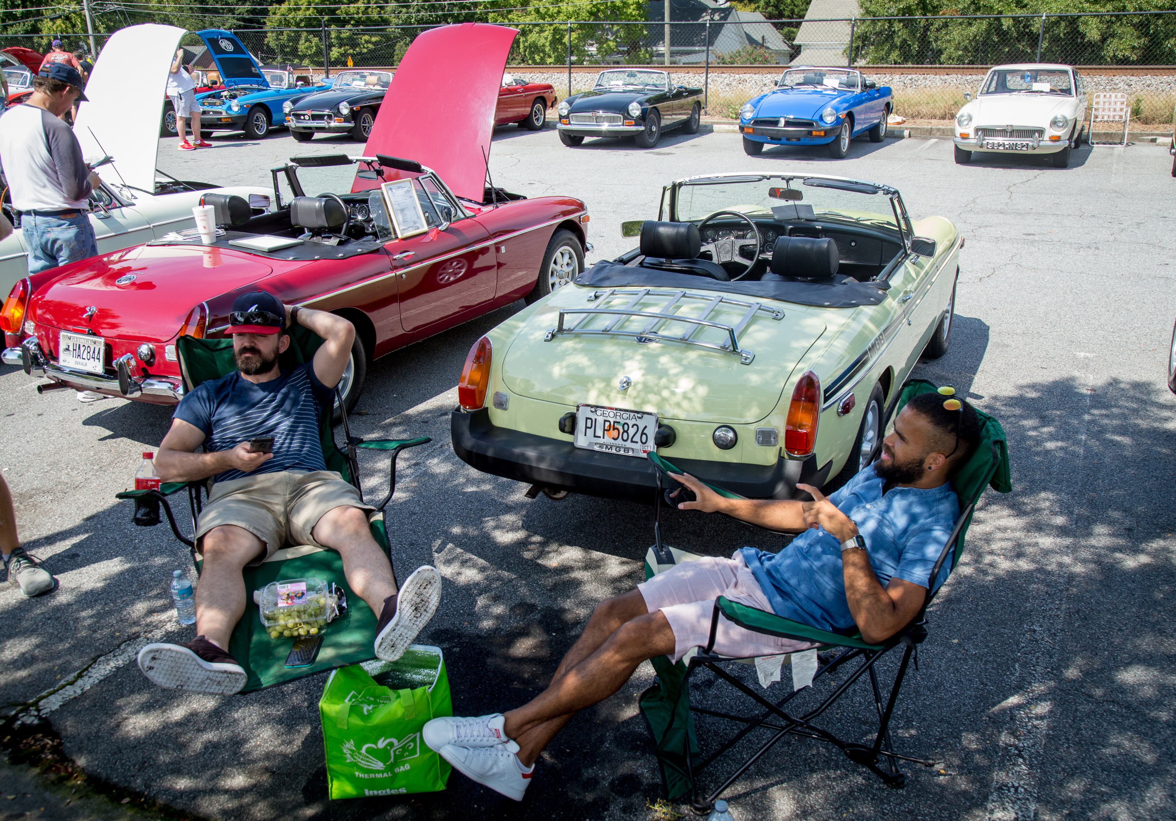 Caris Cousineau (left) and Stephane Arel hang out in front of a 1977 MGB roadster during the 8th annual Atlanta British Car Fayre in downtown Norcross on Saturday, Sept. 8, 2018. (Photo: STEVE SCHAEFER / SPECIAL TO THE AJC)